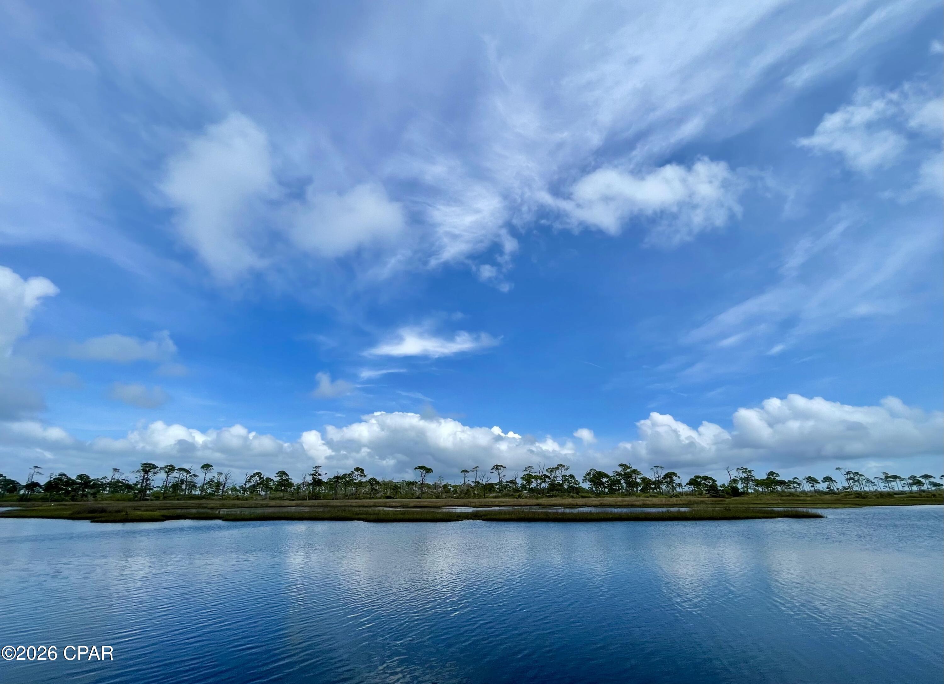 A rare opportunity for a Bayfront lot on North Cape San Blas. This large lot is over 1.18 acres (per plat) and with 100' plus of St Joseph Bay frontage with substantial improvements. Parcel is partially cleared for a homesite yet still has a nice variety of native foliage. Located only 1/3 of a mile from St Joe Shrimp Company and 1/2 mile from Scallop cove this parcel is in a great location and in the heart of the Pig Island channel for great boating access. Onsite amenities include a 24' x 24' pole barn with enclosed storage shed, finished dock with power and boat lift( needs some repair), drive way with gate, water tap paid/ installed, and cleared gravel base into the property. Owner has site plan, house plans, and survey on file. Don't miss out on this excellent opportunity to get ahead of much of the starting work in order to enjoy the bay! Some dimensions were taken from the Gulf County Property Appraisers office, please verify if important.