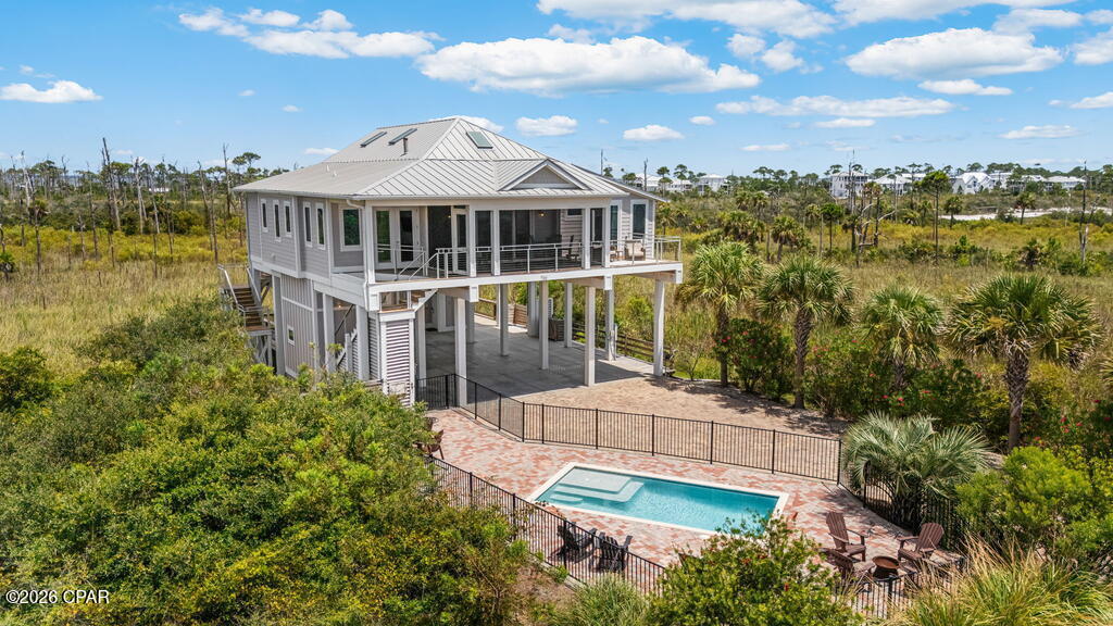 766 Secluded Dunes Drive puts you in one of the North Cape's most private settings, tucked inside the gated community of Secluded Dunes, abutting St. Joseph Peninsula State Park and just a few steps from the beach. This rare, one story 3-bedroom, 4-bath, 1st-tier Gulf home offers plenty of room to spread out, a private pool and hot tub, multiple outdoor living spaces, and the kind of setup that works especially well for life on Cape San Blas. The main living area is open and comfortable, bringing the kitchen, dining, and living spaces together with plenty of room for everyone to gather. The kitchen features a large island with additional seating, while multiple decks extend the living space outdoors. The front porch includes both screened and open areas, and the Gulf-view sun deck is a favorite spot for sunsets, stargazing, or simply enjoying the breeze. Out back, another screened deck with a gas grill simplifies outdoor meals. The primary bedroom takes advantage of the Gulf views with access to the front sun deck and a private bath featuring a double vanity, walk-in shower, and heated floors. Two additional bedrooms each have ensuite baths, and the bunk room offers a triple twin bunk with trundle and its own deck access. An elevator services all floors, and the laundry room includes a utility sink along with a Speed Queen commercial washer and dryer. Outside is where this property really earns its Cape San Blas credentials. The private pool and hot tub are surrounded by space to relax after the beach, with a convenient half bath nearby. There's also a fish-cleaning station for the day's catch, a storage area with a full-size refrigerator, and parking for approximately 6-8 vehicles with room for a boat. With Gulf views, generous outdoor spaces, a private pool and hot tub, boat-friendly parking, and easy beach access, 766 Secluded Dunes Drive is set up for how people actually want to spend their time on the Cape.
