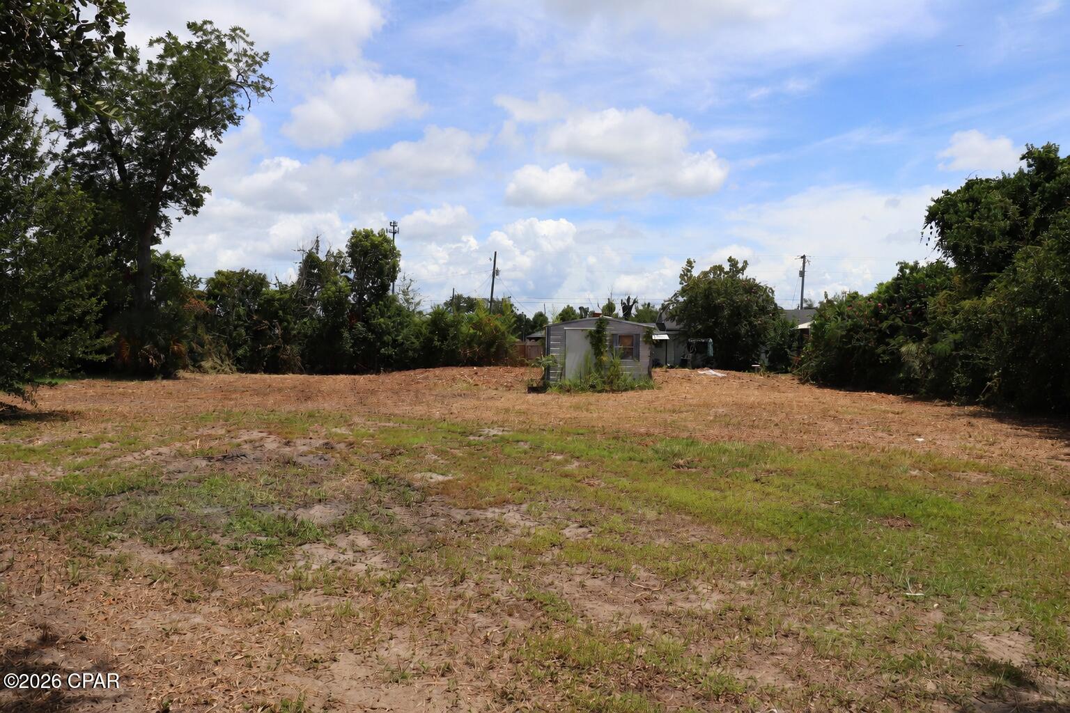 0.29-acre residential lot in Highland City, Panama City. 100 x 127 ft, mostly cleared, paved-road access, no HOA, electric on-site, septic tank with public sewer available.

Vacant residential land at 3030 Headland Avenue in Panama City offers approximately 0.29 acres in the Highland City subdivision. The parcel measures about 100 x 127 feet and has paved-road access with no HOA. Much of the parcel is cleared, with mature trees and vegetation around portions of the perimeter. Present zoning is listed as residential single-family.

Utility information provided in the listing reports electric on-site, public sewer available, and a septic tank on-site. Because both public sewer availability and an existing septic system are reported, buyers should independently confirm connection requirements, capacity, tap fees, and suitability for their intended plans before purchase.

The seller's signed vacant land disclosure reports no known wetlands, flooding, drainage problems, soil movement, sinkhole issues, or other disclosed material conditions in the sections provided. The separate flood disclosure indicates the seller has no knowledge of flood damage during ownership and reports no flood-related insurance claims or flood-damage assistance.

Buyers should independently verify zoning, parcel boundaries, setbacks, utility availability, connection requirements, building requirements, and suitability for their intended use with the appropriate local authorities.