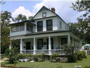 PRICED BELOW CURRENT APPRAISAL-Landmark bay view historic district home built by George Marshall at peak of Apalachicola lumber boom in 1907. Foyer and staircase highlight local craftsmanship, style and design. High ceilings, crown molding, four fireplaces, built-in cabinets and bookcase, oak and heart pine floors, open porches, widow's walk, all on large corner property with outbuildings. New roof in 2008.