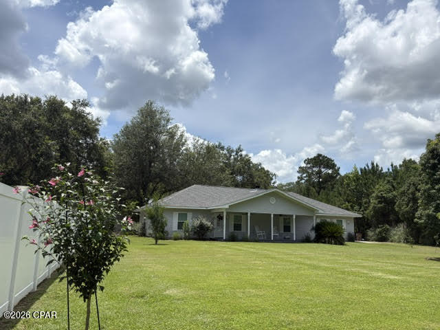 Imagine being just 30 minutes from your front door to the pristine, white sands of Mexico Beach.  And for those who like to fish, 1 minute drive to Dead Lakes Park boat ramp. Boating & fishing in minutes in Dead Lakes which flows into the Apalachicola River. This move-in-ready home offers a perfect blend of comfort, style, and convenience, ideal for entertaining family and friends at home or enjoying the nearby beach. Featuring a spacious open living area with a split-bedroom floor plan, this well-maintained property includes a galley kitchen equipped with newer stainless steel appliances, granite countertops, and a newly added built-in pantry in the breakfast room. The garage boasts added cabinets and countertops, plus a half bath in the utility room for added convenience. The home also includes new chain link fencing in the backyard, fruit trees, nicely landscaped front yard, a storage building, and a privacy fence along the property line for your outdoor privacy. Enhanced curb appeal comes from new shutters on the front of the home, and the master bedroom features a stylish barn door for privacy and separation into the en-suite master bath. Additional updates include new blinds throughout, and a working fireplace in the living room. The roof, HVAC, and water heater are estimated to be just five years old, ensuring peace of mind for years to come. Located on a quiet dead-end street in one of the best areas of Wewahitchka, this home is in Flood Zone X, making it a safe and reliable investment. Don't miss out on this rare gem!