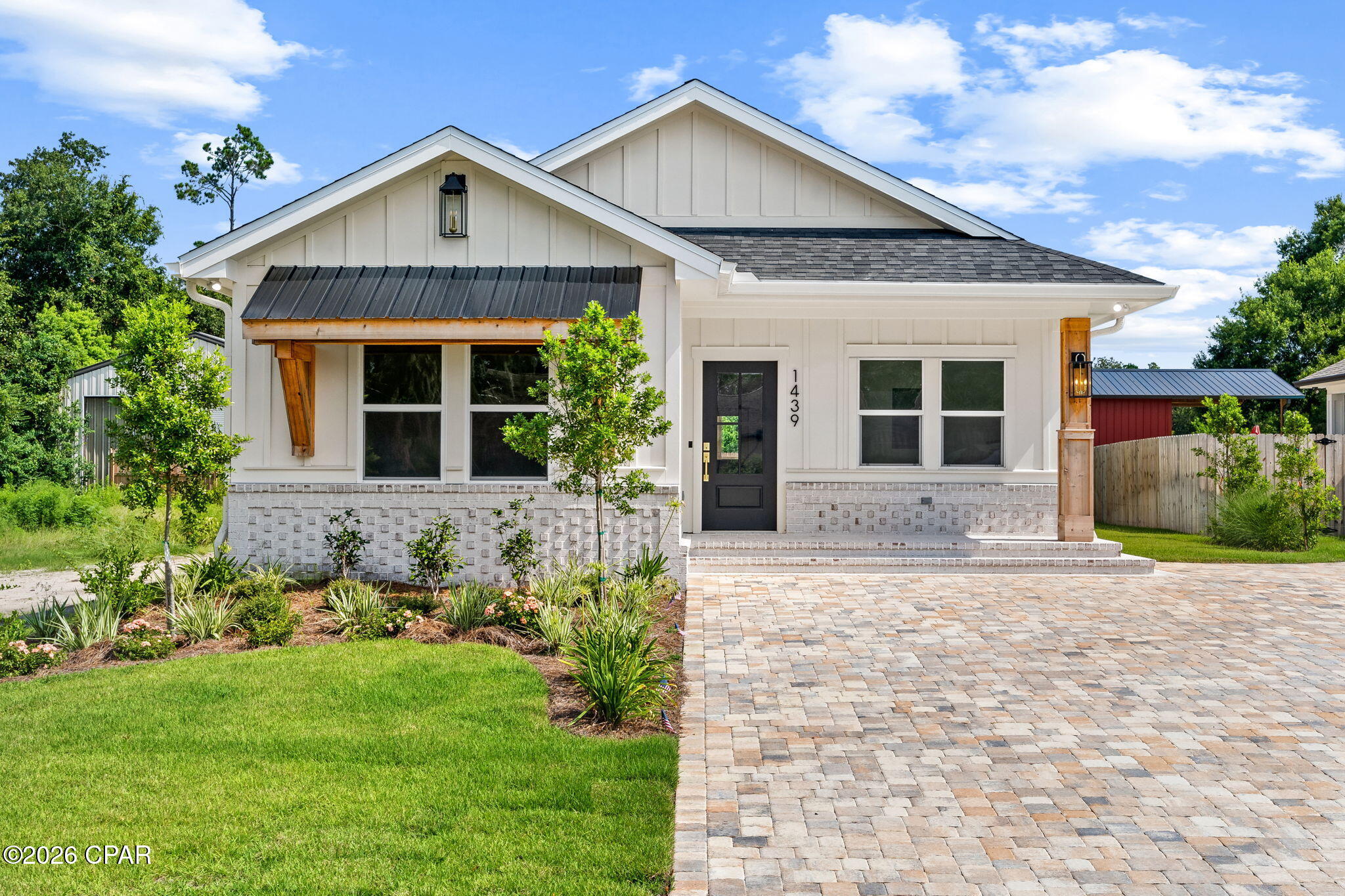 100% Financing Available with USDA Financing!

Welcome home to 1439 1st Street in Panama City, FL -- a beautifully updated 3-bedroom, 2-bath home offering 1,475 square feet of thoughtfully designed living space on a spacious 50' x 150' lot, packed with custom finishes throughout. Step inside to find vaulted ceilings, arched hallways, and warm cedar accents that give the home a distinctive, elevated feel, along with custom millwork carried throughout the home.

The kitchen is a true showstopper, featuring custom cabinetry and countertops, crown molding, a pantry, and upgraded white appliances finished with striking gold hardware. The island is finished in leathered titanium granite with quartz perimeter counters, and a custom pecky cypress hood range serves as the centerpiece. A custom-built pantry door in knotty pine with rain glass adds another layer of character, and a custom juniper mantel brings warmth to the living space. Luxury lighting fixtures carry the same elevated style throughout the home.

The primary suite is a private retreat, featuring a rough-cut pine coffered ceiling, a juniper-surround soaking tub, leathered granite finishes in the en-suite bath, a custom tile shower, dual vanity, and a spacious walk-in closet with custom built-ins. A marbled tile shower and granite finishes carry the same craftsmanship into the hallway bathroom.

Outside, the fully fenced backyard offers privacy and space to enjoy, complemented by a built-in sprinkler system and well-manicured landscaping. A paver driveway adds curb appeal, while the 24' x 16' pole barn provides excellent additional storage or workshop space -- perfect for hobbies, equipment, or extra vehicles.