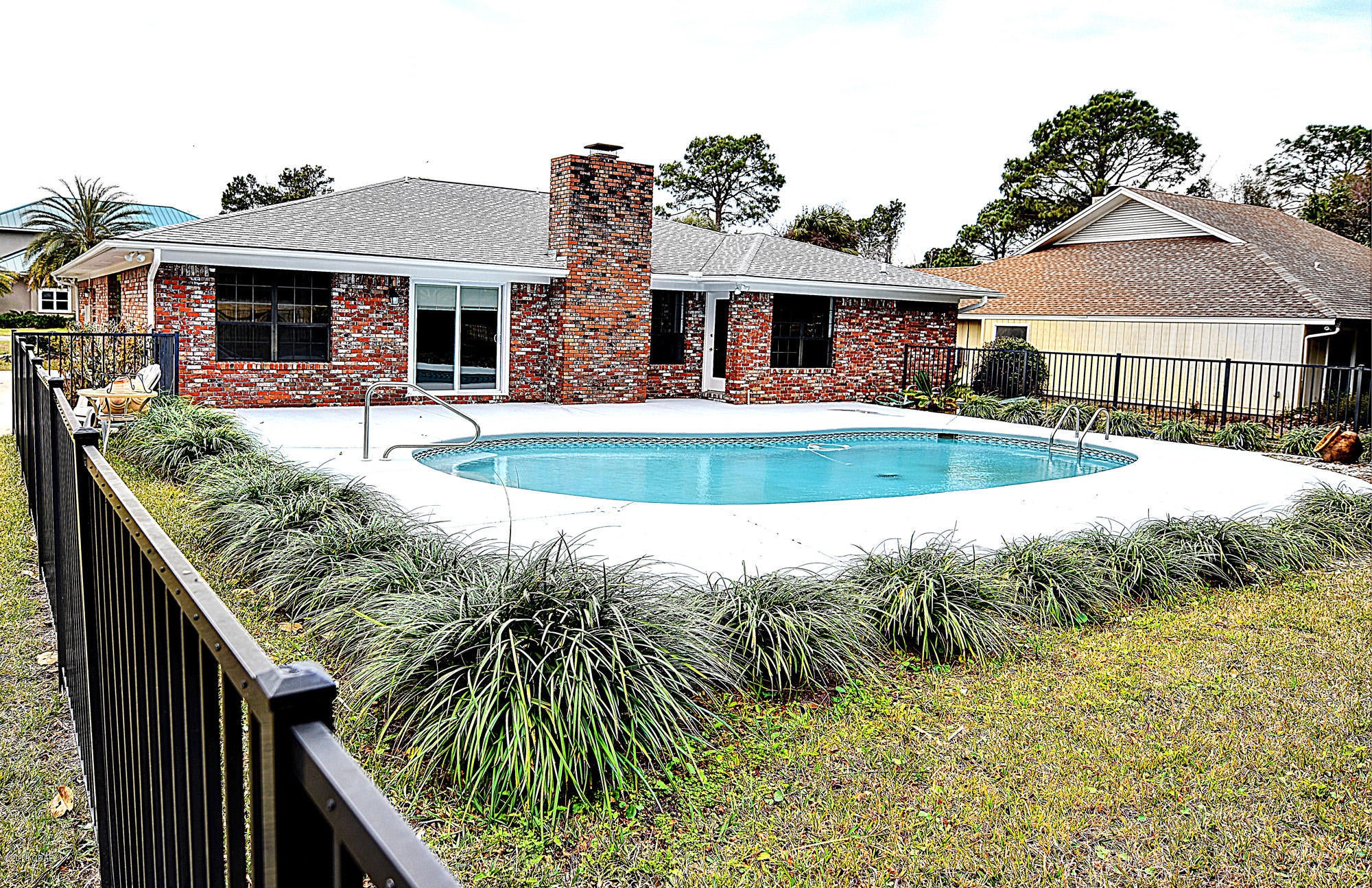 You will love calling this beautiful all brick Bay Point property home!  This home has an in-ground pool, overlooking the golf course in one of Panama City Beaches most sought after gated communities.  This home has been recently renovated and has new bathrooms, flooring, paint and more.  Bay Point features a full service marina, shops and restaurants in this golf cart friendly community located on the east end of PCB near the Navy Base.