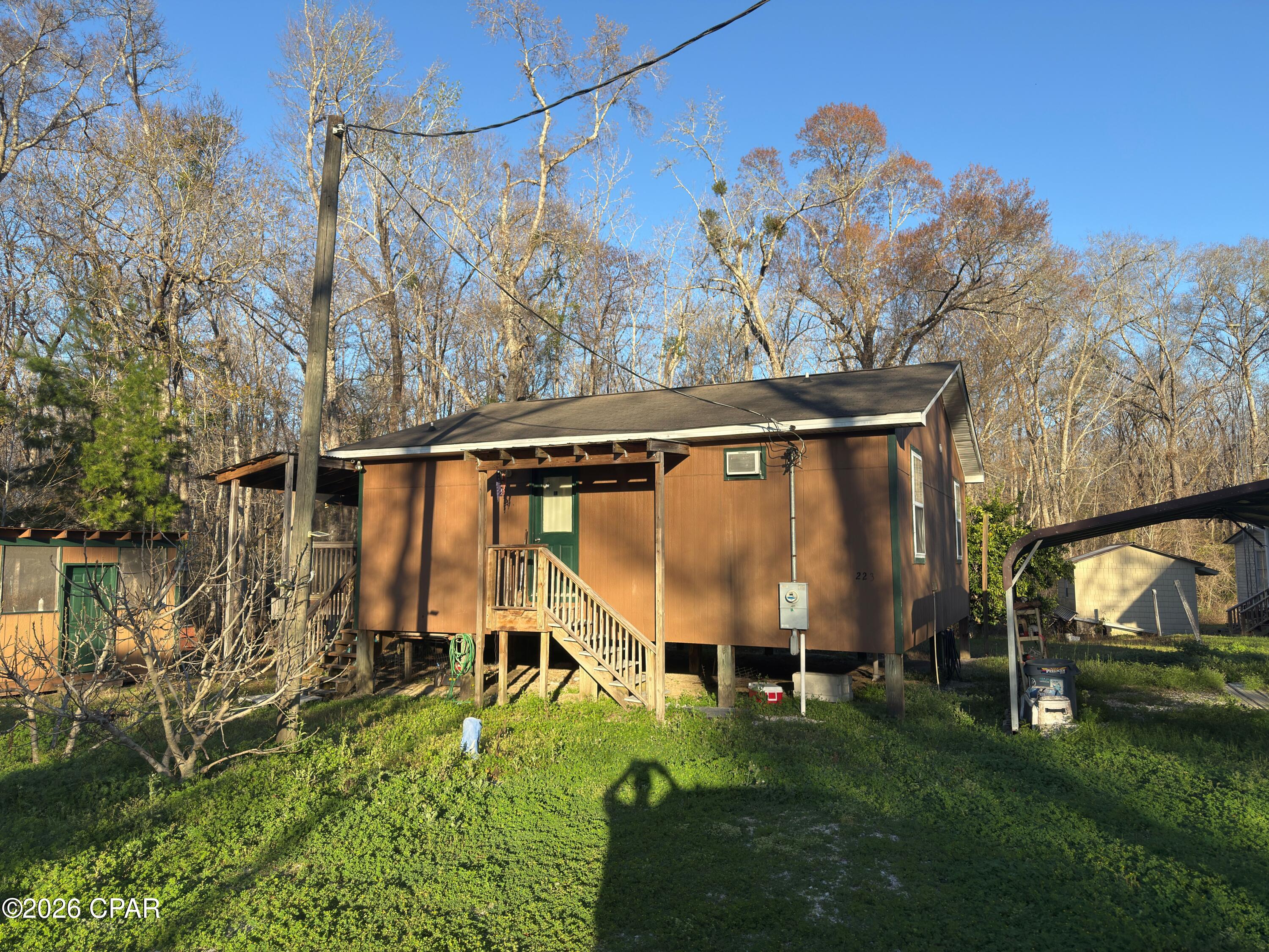 Turn Key cabin that is furnished less than 1500 feet from Bryant's Landing. Enjoy easy access to the Chipola River which is one of North Florida's truly remarkable ecosystems. Cabin is very spacious and is an open plan consisting of 2 bedrooms and 1 bath. Kitchen and dining area that open onto a screened porch suitable for enjoying the morning coffee or afternoon breezes. Plenty of closet space in the main living area as well as the bedrooms. Property also has covered parking as well as two additional storage rooms. Currently water and sewer are community owned and the annual fee is $600.00 for both. No HOA and only Gulf County restrictions. Less than 10 minutes to Wewahitchka, Only 20 minutes to Port St Joe, and about 25 minutes to Mexico Beach. Don't let this sportsman's paradise gem get away. Call today for an appointment