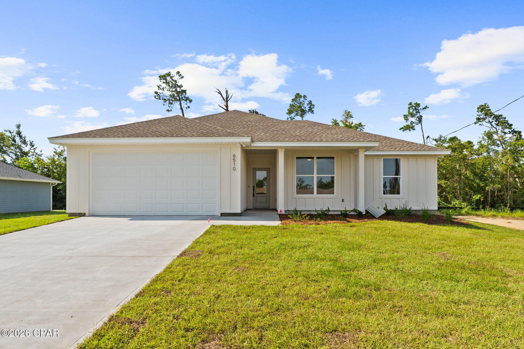 Brand-new construction with quality, comfort, and thoughtful design throughout! This four-bedroom, two-bath home features a desirable split floor plan that gives the spacious primary suite added privacy while keeping the additional bedrooms conveniently positioned on the opposite side of the home. The bright, open-concept living area is enhanced by high ceilings, recessed lighting, and durable flooring that flows seamlessly into the dining space and kitchen. Designed to be both stylish and functional, the kitchen features a large center island, two-tone cabinetry, stainless steel appliances, generous storage, modern finishes, and plenty of workspace for cooking and entertaining. The primary suite offers a comfortable retreat complete with a beautifully finished private bath, dual vanities, and a walk-in shower. Outside, the two-car garage, welcoming covered front porch, covered back patio, and spacious yard provide even more room to relax and make the property your own. Conveniently located near Tyndall Air Force Base, East Bay, shopping, dining, and everyday essentials, with easy access to downtown Panama City and Mexico Beach. If you are looking for a thoughtfully designed new home that combines modern style, practical living, and a convenient location, 6510 Wallace Road is ready to welcome you home!