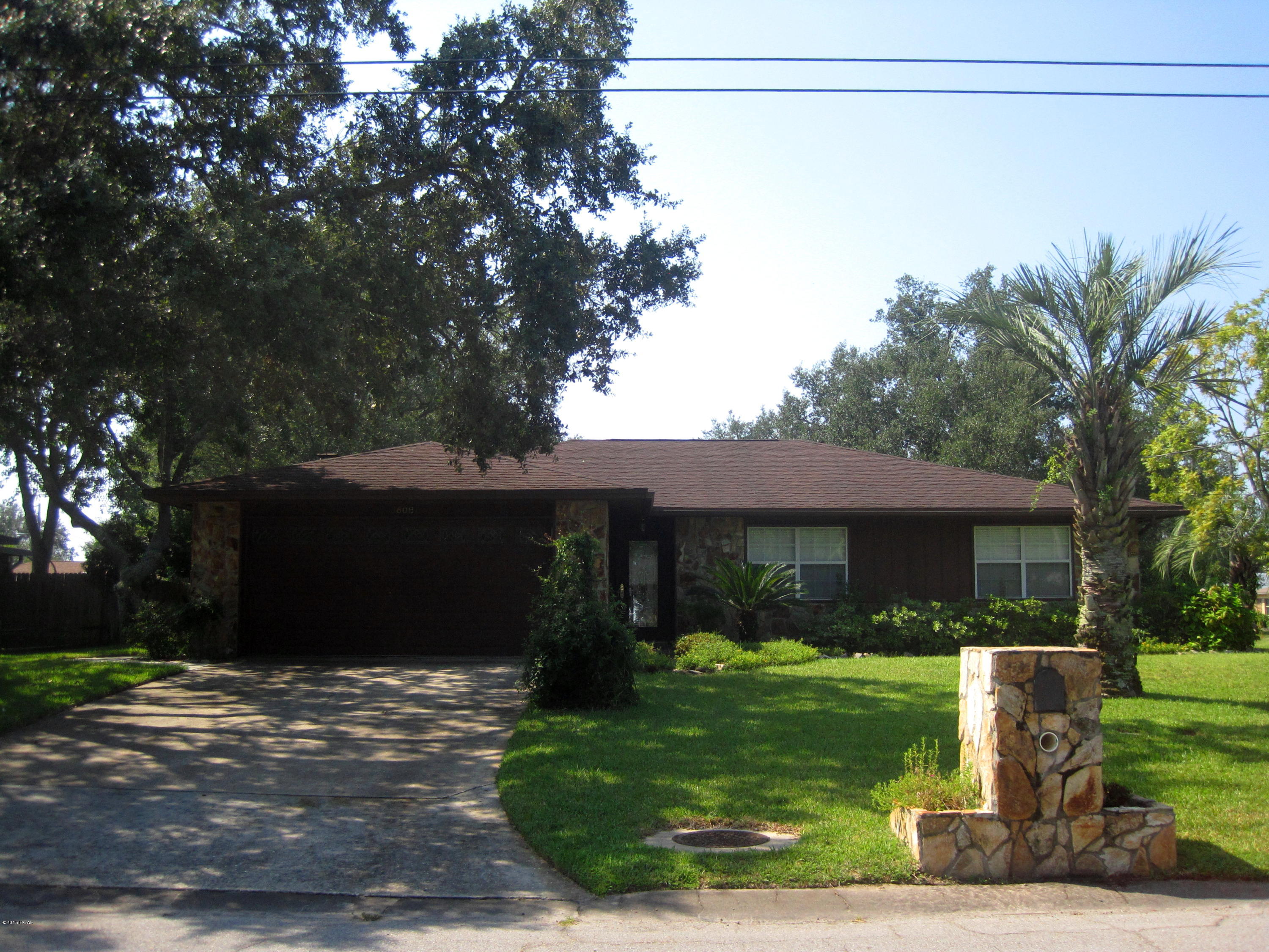 Clean, bright, meticulously maintained!!!  The pride of ownership of this home starts with the beautifully landscaped corner lot with a sprinkler system, boasting pear, peach, lemon, and grapefruit trees along with the oaks, hibiscus, camellias, and gardenias.  The exterior features stone siding as well as wood that was replaced around 2012.  Inside, the living room is large but quite cozy with a stone fireplace and French doors that open to a generous covered patio.  The kitchen is bright with newer appliances and room for a breakfast table.  The laundry room is off the kitchen and includes the washer & dryer. Just off the kitchen is the spacious dining room that features a beautiful chandelier.  The bedrooms are all quite large, and one includes built in shelving. The large garage includes workshop space, and there is a garden shed as well in the back yard.  The home includes newer baseboards, carpet, and paint, insulated windows, and a transferable Terminix termite protection plan.  The seller believes the roof, HVAC, and water heater (on a timer) to be about 3 years old.  The property is also eligible for 100% financing through Rural Development, and it is not in a flood zone.