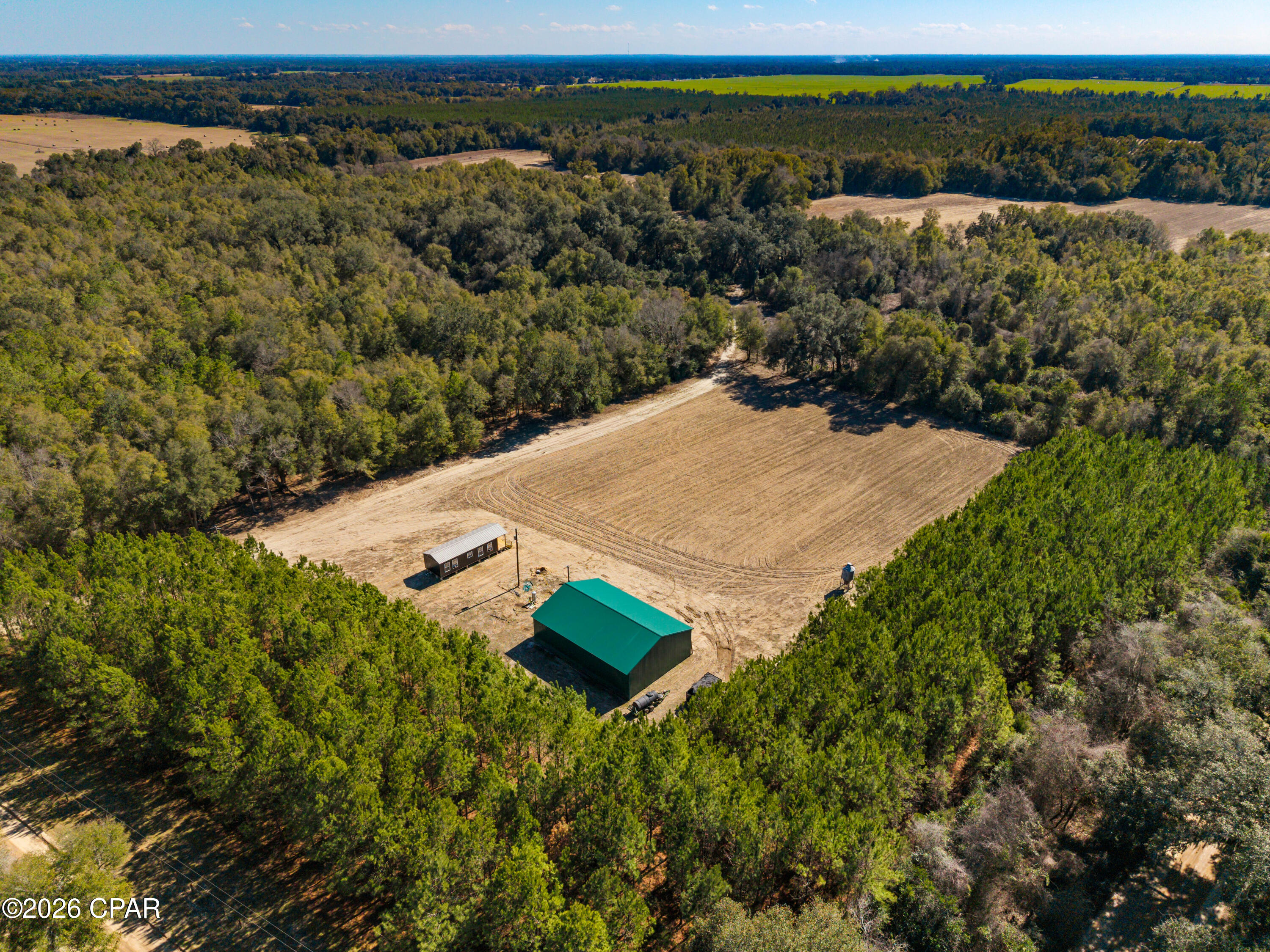 Sylvania Plantation Hunting Tract is a 125± acre hunting, recreational, and potential homesite property located in the Greenwood area of Jackson County, Florida. It's a well-laid-out tract with privacy, established improvements, and land that's easy to own and enjoy.

The property sits on all four sides of an intersection along Nubbin Ridge Road and Sylvania Plantation Road. A gated and fenced entrance provides security and privacy, and the internal road system allows the property to be used efficiently from corner to corner.

The land is a practical mix of open ground and timber, including interior agricultural row crop fields, planted pine timber, and hardwoods with scattered mature live oaks. The live oaks give the property a classic North Florida feel, and several areas are naturally suited for a beautiful homesite overlooking fields and woods.

The property is set up turnkey for hunting, with established stands and feeders included in the purchase. Surrounding ownership consists mainly of large agricultural and timber tracts, which helps keep hunting pressure low. This area of Jackson County is known for producing quality whitetail deer.

Improvements include a custom-built 14x48 cabin, a newly constructed 40x60 pole barn, water well, and power already in place, allowing the property to be used immediately.

Sylvania Plantation Hunting Tract is located approximately 8 miles from both Alabama and Georgia. Lake Seminole is also located nearby and provides 37,500 acres of excellent duck hunting, fishing, and access to multiple public boat ramps.

This is a solid, well-located property that offers a good balance of hunting, recreation, and future homesite potential.