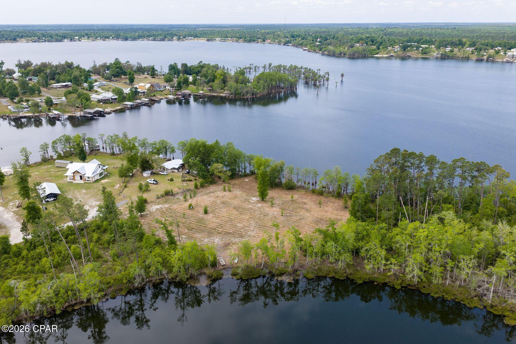 Welcome to the perfect waterfront retreat on the pristine shores of Compass Lake! This beautifully cleared ±1.6 acre lot boasts 200 feet of waterfront on Compass Lake with a gentle slope leading to a level entry, making it ideal for swimming, sunbathing, and enjoying the breathtaking lake views. The rear of the property features 100 feet of waterfront on Black Pond that's filled with bass, bream, and blue gill fish. Slight south west orientation great for sunsets and summer breeze. With direct access to the crystal-clear waters, this property is perfect for boating, fishing, sailing, and water sports. Compass Lake is an expansive, 600-acre spring-fed lake located 35 miles north of Panama City Beach, and it's crystal-clear waters and scenic views make it a local favorite for relaxation and recreation. Outdoor enthusiast who enjoy hiking, cycling, and wildlife observation in the surrounding pine forests and rolling hills find this region to be paradise.