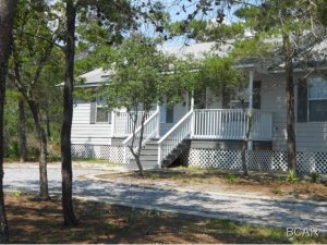 Buy this home with no money down. This home is in immaculate condition and has a great proximity to both the west end of Panama City Beach and 30A area. Enjoy the Lake Powell area with its versatile park for gatherings or to launch your boat or waverunner from the Boat Launch across the lake from Wild Heron. This cute home that was built in 2000 at the West End of Panama City Beach consists of 4 bedrooms and 2 full baths. This property also has enough room to build a garage or out building. Lots of windows make the inside bright and cheery. Home was recently painted and has new flooring with real wood floors in Living room and Master Bedroom. A few new upgrades. Circular Drive and a large deck across the back of house makes this the perfect home for the price. This home is in quiet area of Lake Powell. Huge lot. Will pass any inspections . No waiting to move in, this is a regular sale. Why RENT when you can OWN and pay less. Owner is a Lic Fl. Realtor