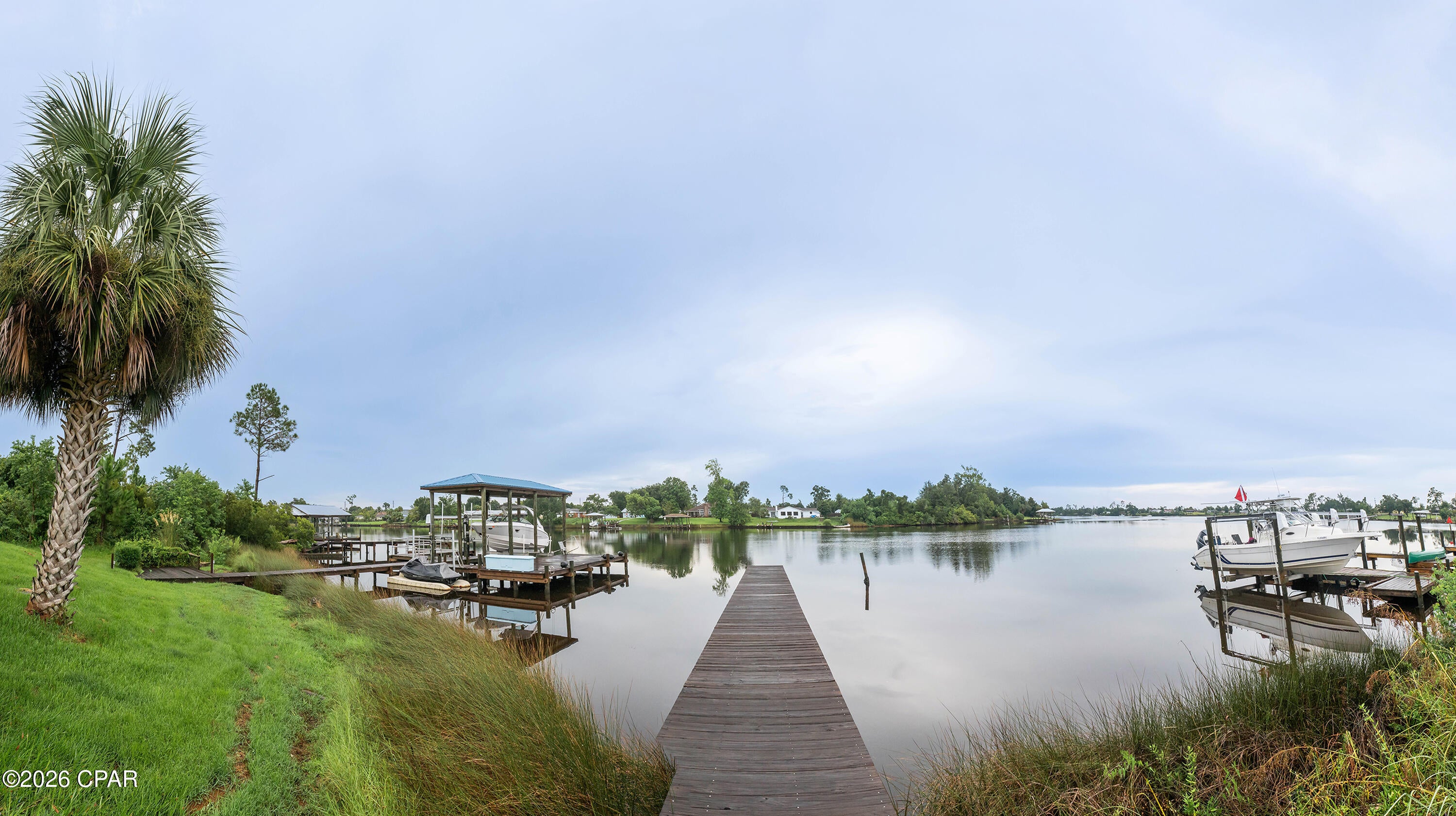 Looking for your extremely affordable waterfront slice of paradise to park your boat with deep water access that leads to the gulf?  Look no further!  This home boasts plenty of living space at nearly 1700 square feet of heated space and waterfront access all without the hassles that come with a single family home.  The grounds are maintained for you.  With a roomy 2 car garage, you will have space to store your cars and tools and with a shared dock, you'll have a place to park your boat or water toys.  Overflow parking is also on sight at no extra charge.  The stone fireplace makes for cozy nights in the winter.  This home needs some updating and TLC, but with a newer metal roof and sturdy concrete exterior,  you know you are structurally sound while improving the interior of the home.  And for those looking to earn sweat equity while living in the home, opportunities like these don't come along often.