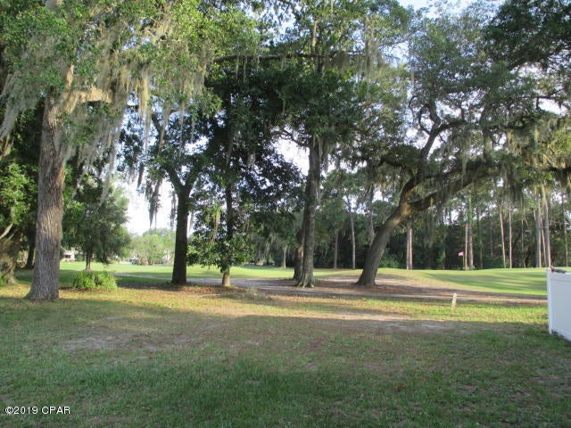 Purchase this rarely available individual townhouse lot in the secluded Country Club in Lynn Haven overlooking the golf course to build your home on. Closed community with a guard house that is partially manned for your security. You will see people walking, running, walking their dogs and playing golf. Join the Country club and enjoy all the amenities it has to offer. Call today