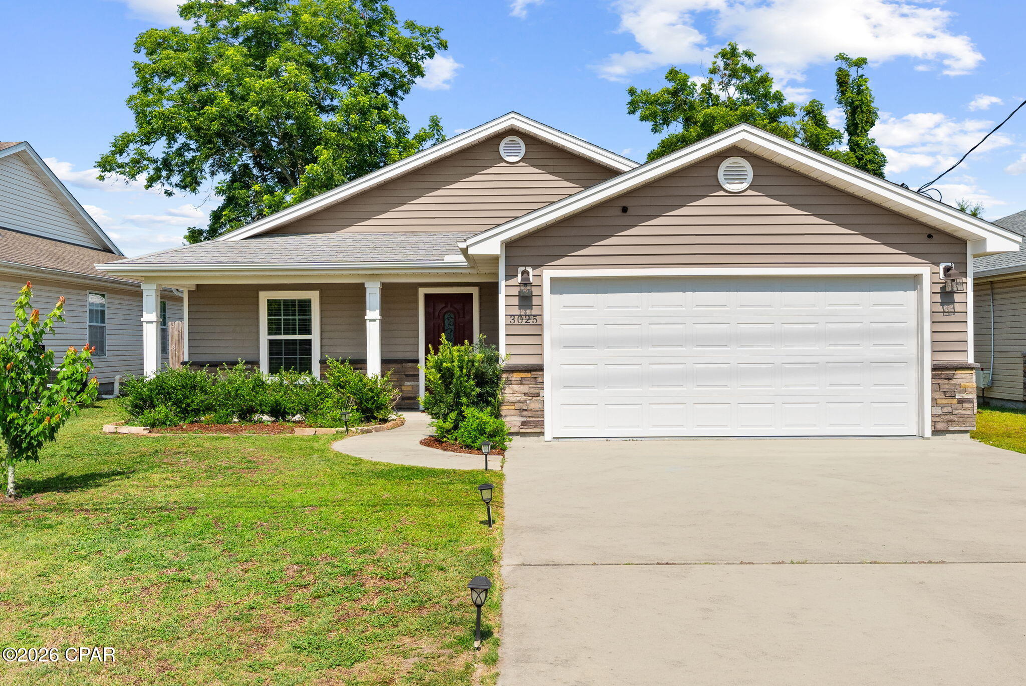 Welcome to 3025 Sarasota Avenue, a beautifully maintained 2020-built residence offering the perfect combination of modern finishes, everyday functionality, and a highly convenient Panama City location. Featuring 3 bedrooms, 2 bathrooms, and a desirable open-concept design, this home is ideal for first-time homebuyers, downsizers, or investors seeking a low-maintenance property in the heart of Bay County. Inside, you'll find waterproof vinyl flooring throughout, granite countertops, and a spacious living area highlighted by a striking tray ceiling, custom shiplap accent wall, electric fireplace, and built-in entertainment center. The well-appointed kitchen offers ample workspace and storage, while the primary suite features a double vanity and private bath. The exterior showcases attractive stone and vinyl accents that create exceptional curb appeal. Enjoy both front and rear covered porches, gutters, a fully fenced backyard with swing set, and an extended concrete patio perfect for grilling, entertaining, or relaxing outdoors. A stone paver pathway provides convenient access to the backyard, while the two-car garage adds additional storage and functionality. Located in Flood Zone X with no HOA, this property offers added peace of mind and flexibility. Situated just minutes from everyday conveniences, you'll enjoy quick access to Publix, Winn-Dixie, Walmart, and numerous dining and shopping destinations. The home is also conveniently located near schools, parks, and major commuter routes, making daily errands and travel effortless. Combining modern construction, thoughtful upgrades, and an exceptionally convenient central location, 3025 Sarasota Avenue presents an outstanding opportunity to own a move-in-ready home in one of Panama City's most accessible areas.