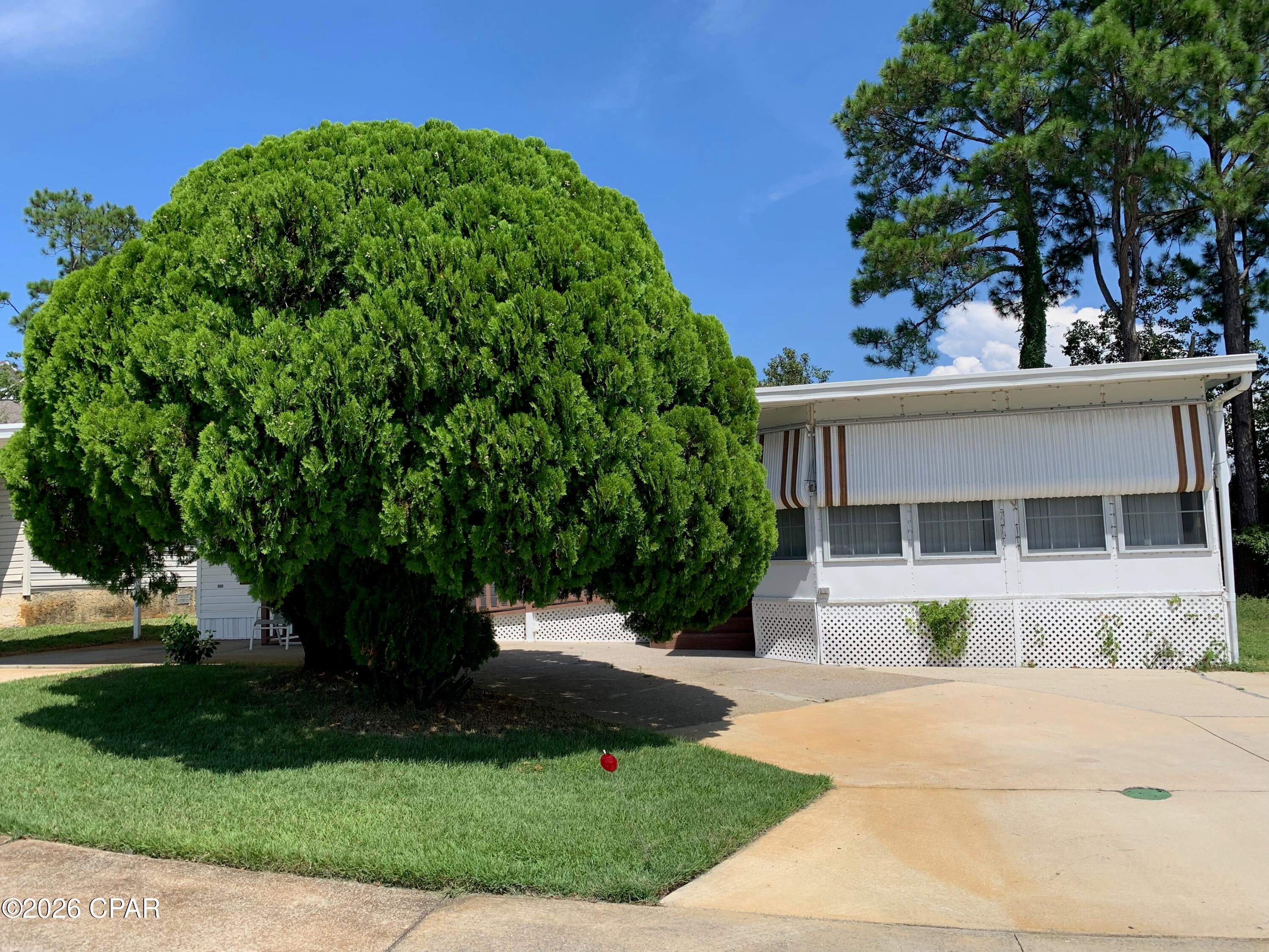 This lovely 3 bedroom 2 bath mobile home is located in the quiet 55+ neighborhood of Greenwood Acres. The ammenities include community pool, clubhouse. HOA includes lawn care, water, sewer, trash, internet and cable. The community is fee simple and you own the land! This well maiintained home has a Florida room plus an enclosed porch.  There is a storage shed that remains. The washer & dryer will remain along with the master bed & matching chest & dresser!  East access to the beaches and Pier Park!  Don't let this one pass you by!