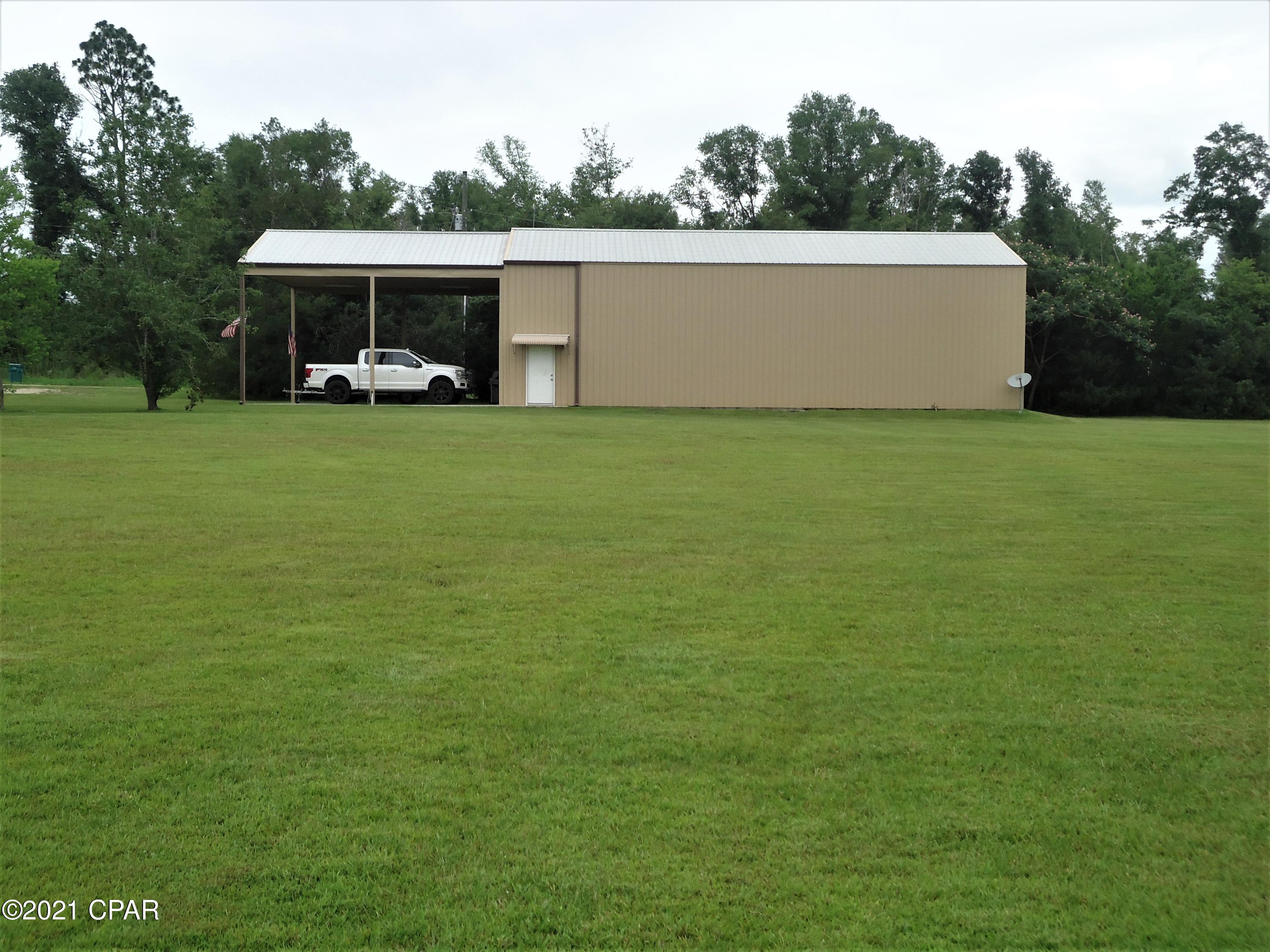 Unique and Special!  Make this stick built metal siding building your own custom barndominium, or live in it as is.   It's 36 ft  x 60 ft with 16 ft Ceilings.  Built with spray foam insulation.  Covered 36 x 17 ft concrete pad parking.    The building also has a bath that includes a washer and dryer with a folding area plus storage.  Upstairs is an office.  It has two massive electric roll up doors and a half screen to put in one of doors to enjoy the outdoors without the bugs.  It has epoxy finished floors, LED Lighting, C/H and Air, and 80 gal hot water heater.  It also comes with an immaculate 2005 39 ft Teton 5th Wheel that is perfect for one or two people.   The property also has a pond. Too much to list must see!!!