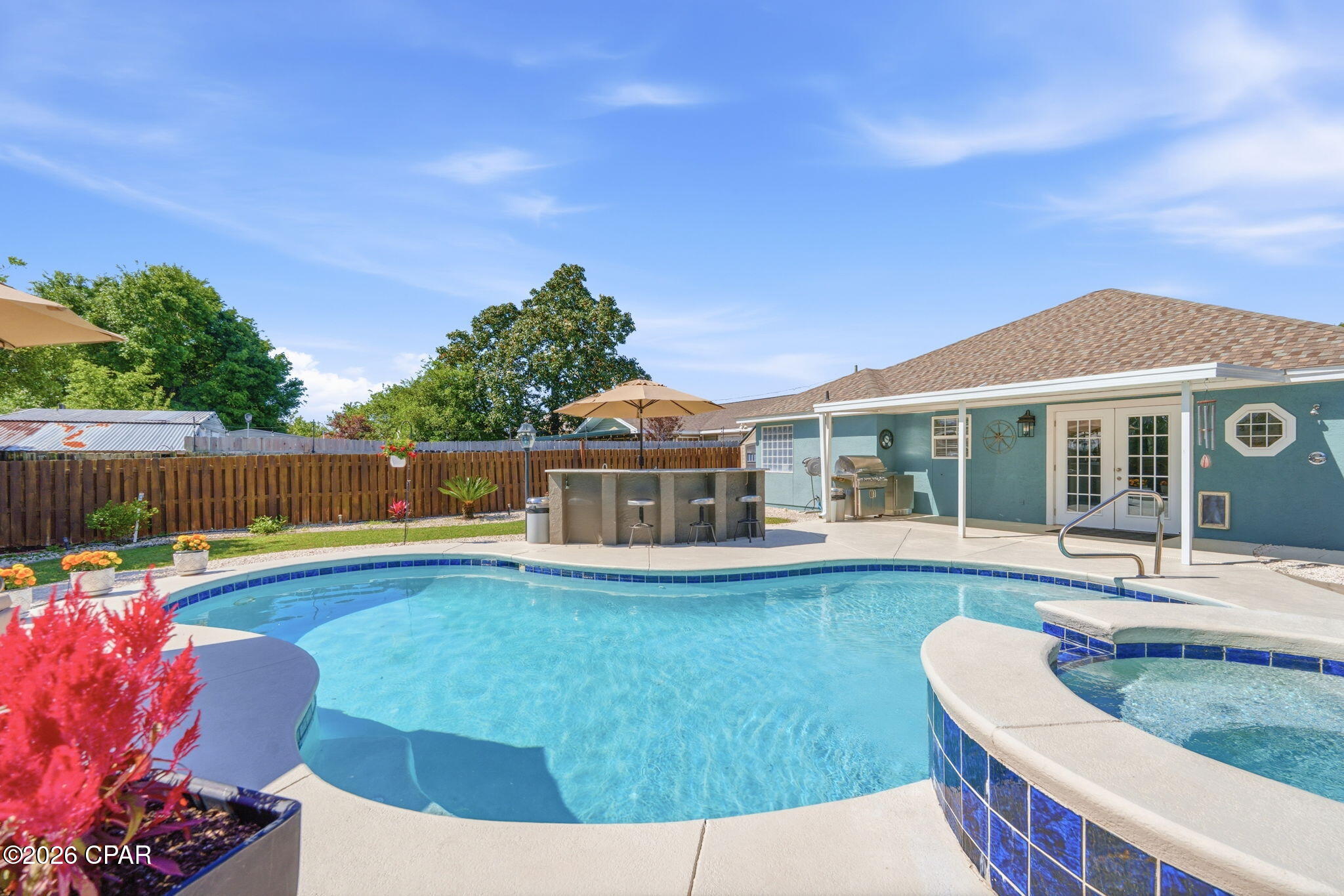 Step into coastal luxury with this pristine executive-style Beach Home, ideally located less than a half-mile from the sugar-white sands of the Gulf; just a short 10 minute walk to the beach. Completely remodeled from top to bottom with NO expenses spared, this stunning property offers the perfect blend of elegance, comfort, and resort-style outdoor living. Inside, you'll be welcomed by a spacious open-concept living area featuring soaring 10 foot ceilings, beautiful crown molding, and high-end finishes throughout. The gorgeous kitchen is a true showpiece, boasting granite countertops and matching granite backsplashes, along with premium GE appliances that combine style and functionality. The primary suite serves as a private retreat, highlighted by tray ceilings, a large walk-in closet, and a spa-inspired ensuite bathroom complete with a garden tub, walk-in shower, and luxurious rainfall showerhead. The backyard is where this home truly shines. Designed for entertaining, it features a spectacular lighted pool with a tranquil spillover spa and water feature. Both the pool and spa are heated by natural gas, providing efficient year-round enjoyment. Waterway Oasis digital controls allow you to operate and program the system with ease right from inside the home. Outdoor living continues with a built-in Fire Magic natural gas grill eliminating the need for propane tanks. There is a granite-topped outdoor bar with ample seating, and even a heated outdoor shower. The professionally landscaped yard is enhanced by a 24-volt landscape lighting system that beautifully illuminates the trees and planters after sunset, while an automatic sprinkler system keeps everything lush and well-maintained. DO NOT miss your chance to call this place HOME! Come check it out!!