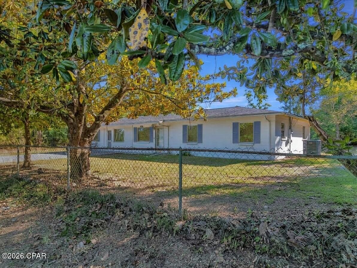 No HOA, 1 Acre of land, 4 bed 2.5 bath, block home! Discover the perfect blend of modern living and rural freedom in this well-maintained concrete block home, nestled on a peaceful, wooded one-acre lot in the heart of Bayou George. With no HOA restrictions, this property offers true independence, featuring a cleared area around the home ideal for parking boats or RVs, complemented by a back concrete patio and separate outbuildings for all your storage needs. The spacious 1,664+ square foot interior boasts an open-concept layout with four bedrooms, 2.5 bathrooms, and attractive hardwood-look tile flooring throughout. The chef-ready kitchen is equipped with a gas range, stainless steel appliances, and stylish barn doors, while a generous walk-in laundry room and gas tankless water heater add modern convenience. Key high-value extras include a private deep well with a Culligan water softener, a 250-gallon in-ground propane tank, and an active AC maintenance agreement with Peaden for added peace of mind. Located just a short drive from the boat ramps at Deer Point Lake and the amenities of Panama City via Highway 231, this move-in-ready gem is the ideal sanctuary for those seeking a wooded retreat with city accessibility. Schedule your showing today!