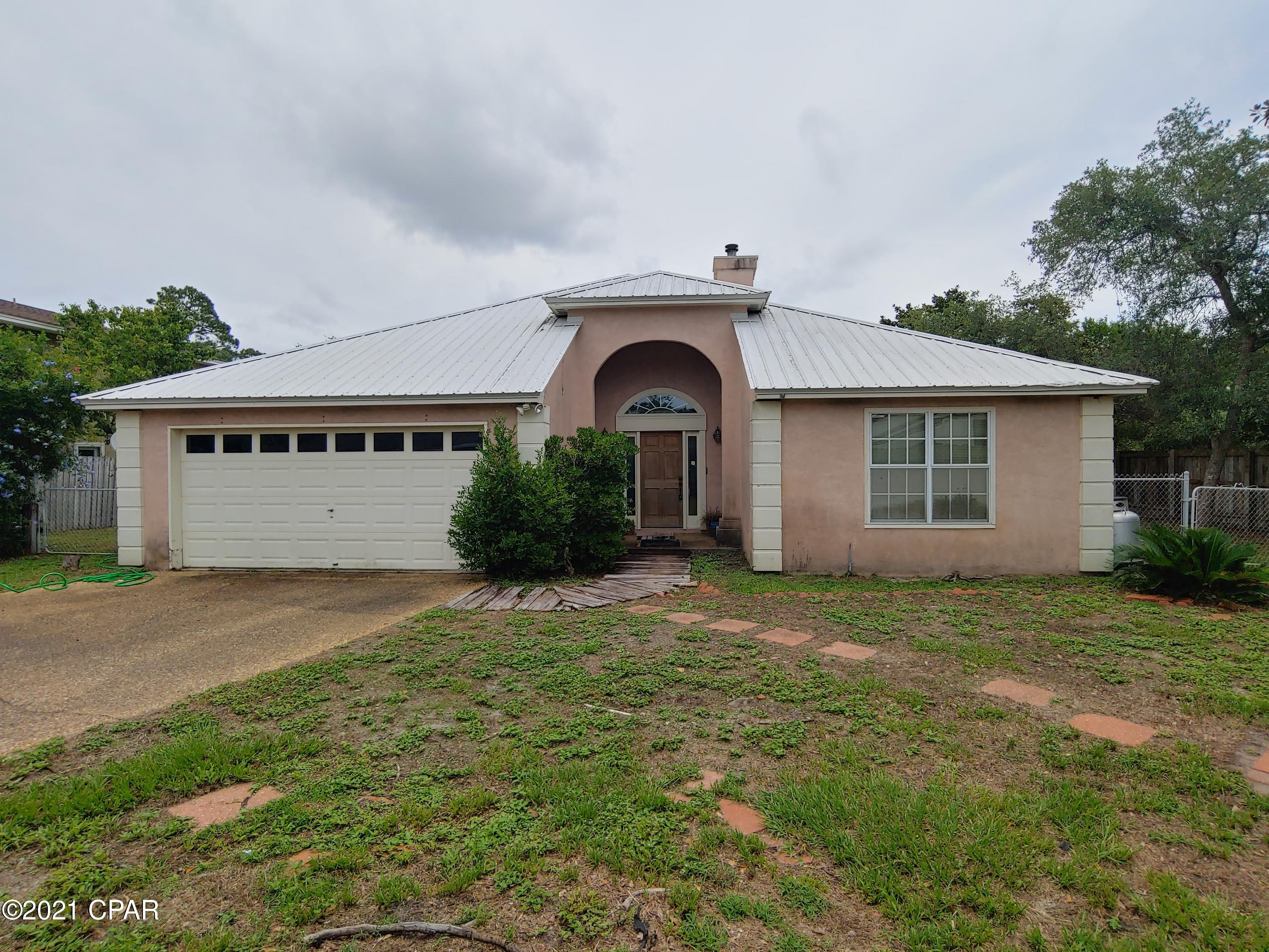 CURRENTLY UNDER CONTRACT, SELLER ACCEPTING BACKUP OFFERS. Quiet PCB neighborhood on a cul-de-sac perfect for those wanting privacy. No HOA in this desirable and cozy neighborhood.  Minutes to beaches, golf, shopping, dining, marinas, and more.

The home needs cleaning and paint to move in but is in otherwise good condition. Featuring Brand New HVAC, 2010 metal roof, skylights, newer water heater, and new fridge. Separated Master Bedroom with dual vanity and dual closets in master bathroom.

Living Room, kitchen, and master bedroom feature 12' ceilings. Patio doors bring easy access to the yard with oak trees and flowering bushes. 

Room for additional parking, pool, storage building, etc. See it today!

All dimensions approximate, buyer to verify if important