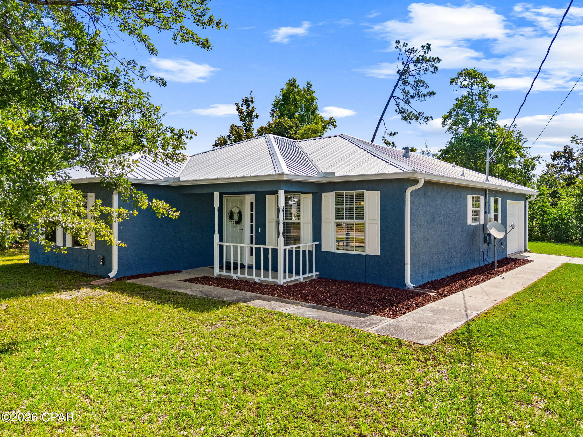 Charming 3BR/2BA home situated on a spacious 100' x 150' corner lot in the heart of Lynn Haven. Conveniently located within walking distance to Cain Griffin Park, featuring pickleball courts, playgrounds, ball fields, and new neighborhood sidewalks. Major updates include a metal roof (2019), HVAC system (2019) with annual servicing, water heater (2020), and freshly painted exterior (2025).

The interior offers a bright living room with abundant natural light, a functional kitchen with ample cabinet storage, and a large laundry room with additional storage space. All kitchen appliances convey. The primary suite features a walk-in closet, double vanity, tub/shower combination, and French doors leading to the back patio. Two additional bedrooms share a hall bathroom with a tub/shower combination and nearby linen storage.

An oversized one-car garage provides additional storage and workspace. The expansive lot is shaded by mature trees and offers privacy, along with plenty of room for outdoor living, gardening, or future improvements. Located in desirable school zones and just minutes from shopping, dining, and everyday conveniences, this property presents an excellent opportunity to own a move-in-ready home in a sought-after Lynn Haven location. *All information and measurements approximate, verify if important.