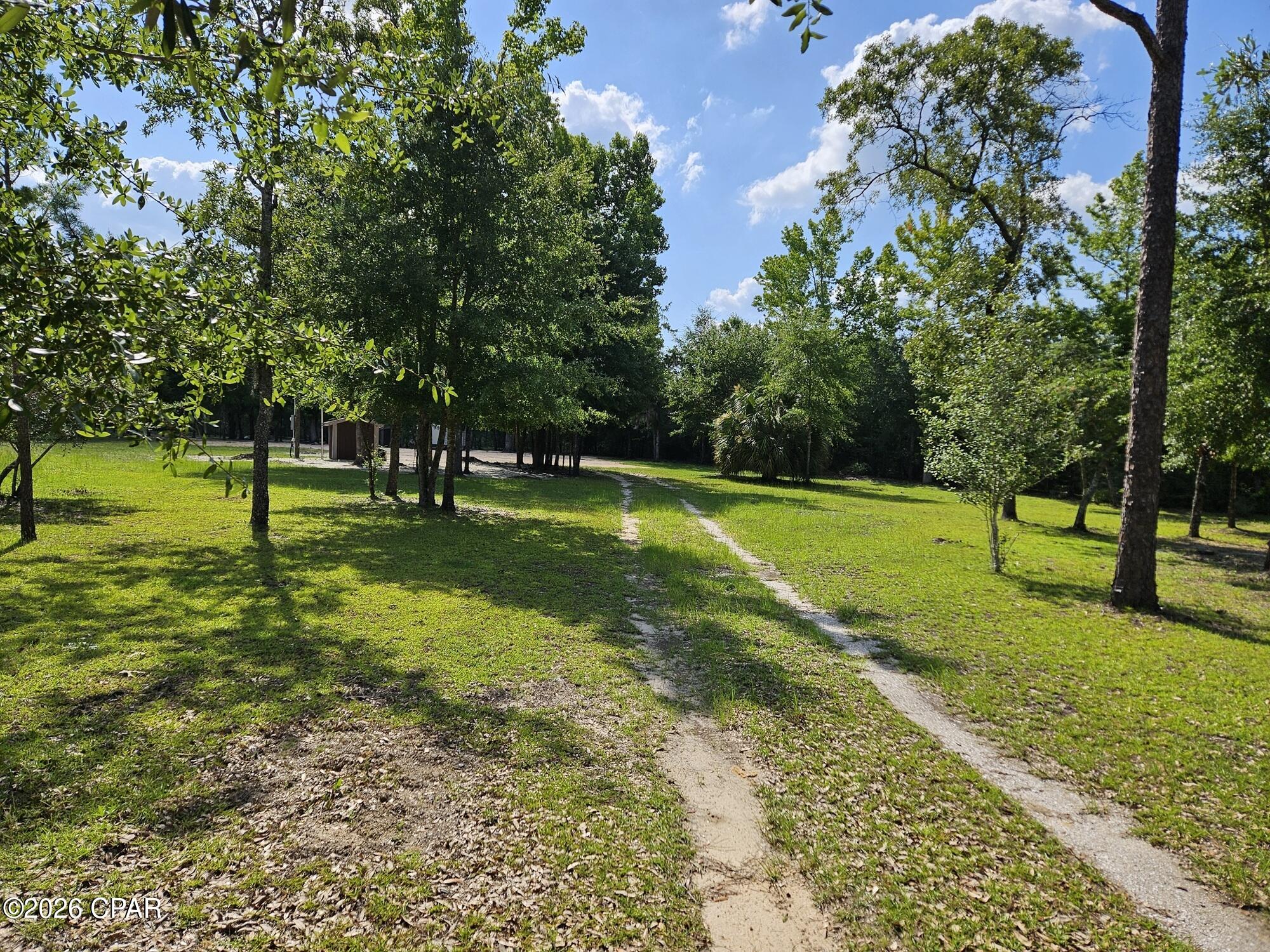 A very nice 5 acre tract of  land with some very nice improvements already completed. First the lot has been completed cleared minus the beautiful collection of original trees as seen in the pictures.  The shed that is on location is fully insulated as the previous owner had it set up where he could come and stay for a few days at a time to keep the property cleaned and manicured. It was set up with an air conditioner a small bed with a fridge and microwave for  simple comforts. There is a well in a enclosed well pump house fully insulated  for all climate conditions. The property is fenced but no fully enclosed. There is also an additional storage shed for tools and supplies. The property has many beautiful shade trees and has been very well maintained. and the original owner has spent a lot of money in completing it to it's current conditions as well as continuously maintaining it's very pleasant condition..