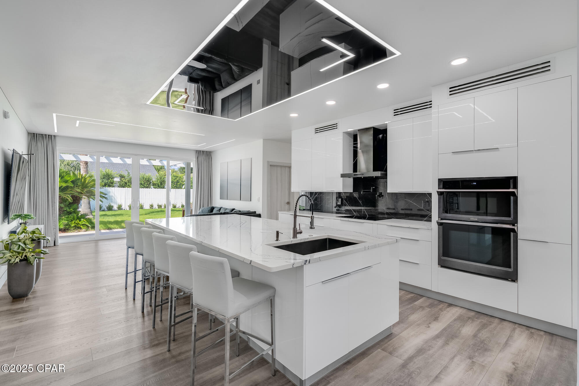 Discover the perfect blend of contemporary luxury and coastal comfort in this beautifully renovated home, ideally located in the highly desirable Palmetto Trace neighborhood. Just minutes from Pier Park, across the street from TopGolf, and a quick drive to the new hospital, this property offers both convenience and style.

Inside, the open-concept living area is bright and airy, featuring sleek recessed LED ceiling lighting, a spacious sectional, and floor-to-ceiling sliding glass doors that frame views of your private backyard oasis. The gourmet kitchen is a showstopper, boasting high-gloss cabinetry, a quartz waterfall island with seating, premium appliances, and a striking black-marble backsplash--perfect for casual dining or entertaining.

The primary suite is a true retreat, complete with a spa-inspired bathroom featuring heated floors, a towel warmer, LED-lit mirrors, dual sinks, a rainfall shower, and a freestanding soaking tub. The large walk-in closet is equipped with custom organizers to keep everything perfectly in place.

Step outside to a fully fenced backyard with lush tropical landscaping, a covered pergola patio for outdoor dining, and a sparkling saltwater pool--your own private escape. Lawn care and pool service are included, so you can spend more time enjoying the Florida sunshine.

Palmetto Trace is known for its tree-lined streets, pedestrian walkways, and two inviting community pools, adding to the neighborhood's charm and livability. With beaches, shopping, dining, and entertainment just moments away, this home offers the ultimate Panama City Beach lifestyle.