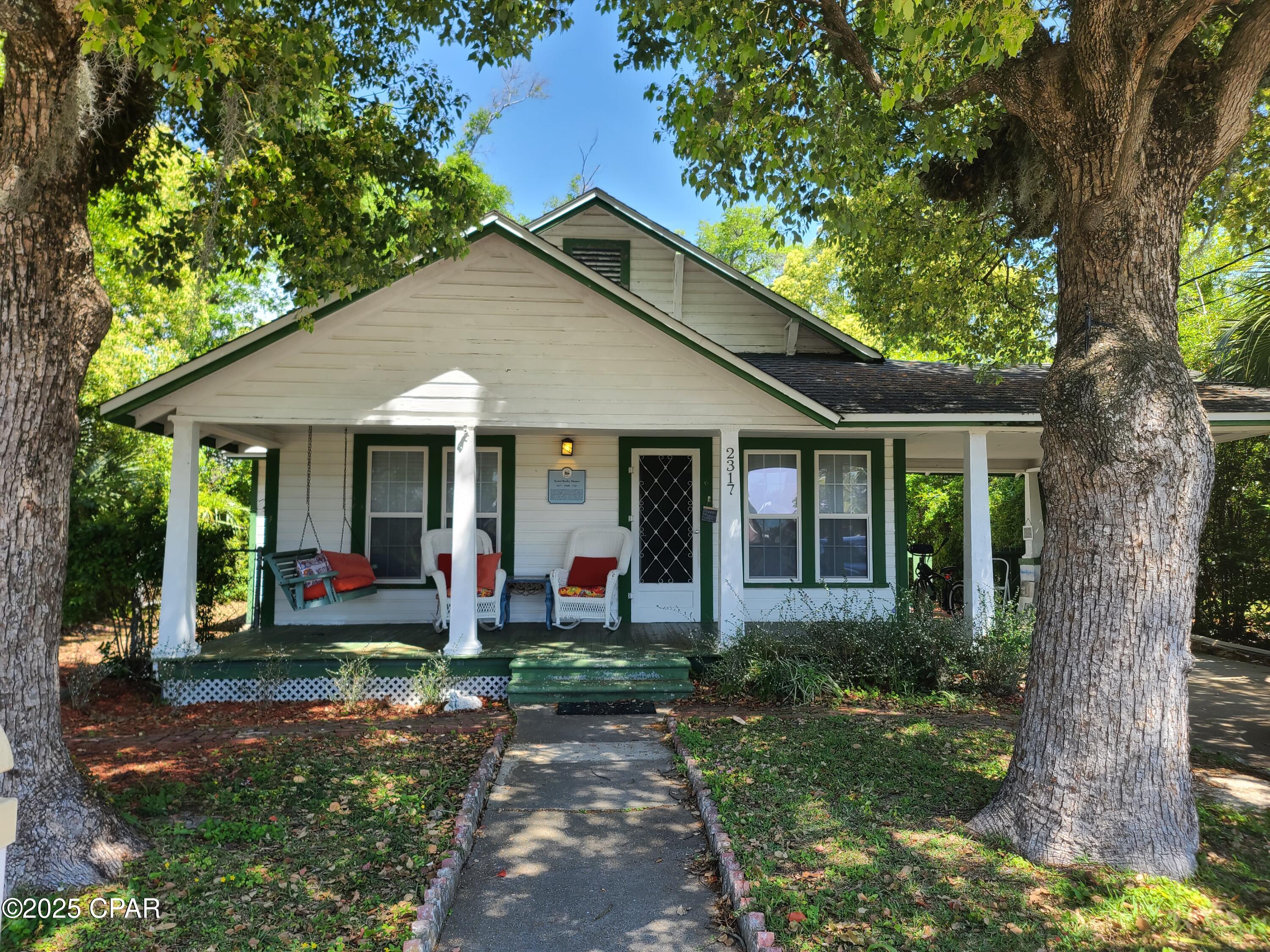 Turnkey Airbnb!  Welcome to a piece of local history with charm, character, and a touch of old Florida magic! Nestled in the heart of the Millville's waterfront community, this unique property invites you to embrace a lifestyle rich in tradition and versatile in opportunity. The main home features 3 bedrooms, 2 bathroom, and approximately 1,472 square feet of living space accented by original pine wood tongue and groove hardwood floors and timeless architecture. Updated around 2007, the well-equipped kitchen blends modern convenience with vintage charm, equipped with stainless steel appliances and thoughtfully designed for everyday function.

Just behind the main residence, you'll find a delightful 1-bedroom, 1-bathroom carriage house spanning 444 square feet--ideal for generating rental income, hosting guests, or unleashing your creativity in a workshop, studio, or home office. Two additional outbuildings extend the potential even further, offering ample space for a shop, storage, or a secret garden hideaway (complete with your own power tools, of course).

The fully fenced yard is shaded by mature oaks and dotted with flowering trees, crafting a peaceful outdoor oasis perfect for coffee mornings or weekend gardening adventures. Whether you dream of raised beds, swinging hammocks, or backyard barbecues, this space is ready for your vision.

Many adorable outdoor living spaces, nooks, lounge spots, a firepit, outdoor shower, pergola, cabana and covered porches invite relaxing.  On the main home, the porch is inviting with french doors into the mud room and coffee bar.
The laundry area is located on the back porch for shared access.  The hot tub is centrally located for shared use in the private backyard.  An area is designated for cornhole or bocce.    

For outdoor enthusiasts, Watson Bayou's public boat launch is just a short walk away, making it easy to spend your weekend on the water. Daily errands are simple, too--groceries, parks, and schools are all conveniently located nearby. Rosenwald High School is within reach for educational needs, while shopping destinations like ALDI and Walmart are only minutes away. Public transit options add ease to commuting.

The location also provides a straight shot to Tyndall Air Force Base, just a 15-minute drive down the road. Whether you're planting roots, making an investment, or simply on the hunt for a home with heart and history, this property delivers something special.

So, if you're the type to admire handcrafted details, enjoy tree-lined streets, and wouldn't mind a bonus backyard cottage, your future just might be calling from the past. Come explore the potential--and see for yourself why this charming Florida gem could be your next great story.

Turnkey Airbnb home and cottage.  The Captains Cottage has been rented both long term ($1200/mo) and short term ($100/night)  Short term rental ready! 

Do Not Disturb.  24 hour notice to show requested.