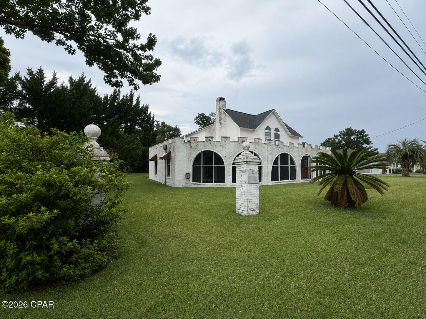 Own a piece of Lynn Haven history with the iconic 'Castle House', a unique 4-bedroom, 2-bath home built on three lots and offering 2381 square feet of living space and over a century of character and charm. Originally constructed in 1912 by Union Veteran L.C. Christopherson, the home was sold in 1913 to fellow Union Veteran Andrew Jackson and his wife, Martha. Jackson served in Company F of the 35th Indiana Infantry.  During the late 1920s, under subsequent ownership, the home's distinctive Spanish-style porch and garage were added while Lynn Haven's City Hall was under construction, giving rise to the property's enduring nickname, ''The Castle House.'' The J.B. Atkinson family resided in the home until 1936, and the property later became part of local legend. Known as ''The Castle House.''  It was rumored to have housed Hollywood icon Clark Gable when he was stationed at Tyndall Field in 1941 for military pilot training during World War II. While never officially documented, the story became widely accepted throughout the community. Today, The Castle House remains one of Lynn Haven's most recognizable landmarks. Its distinctive blend of architectural styles, fascinating history, and timeless character create a truly rare opportunity to own a home on three lots, which is as memorable as it is historic. 
All measurements and square footage are approximate and should be independently verified by the buyer. Information is deemed reliable but not guaranteed.
