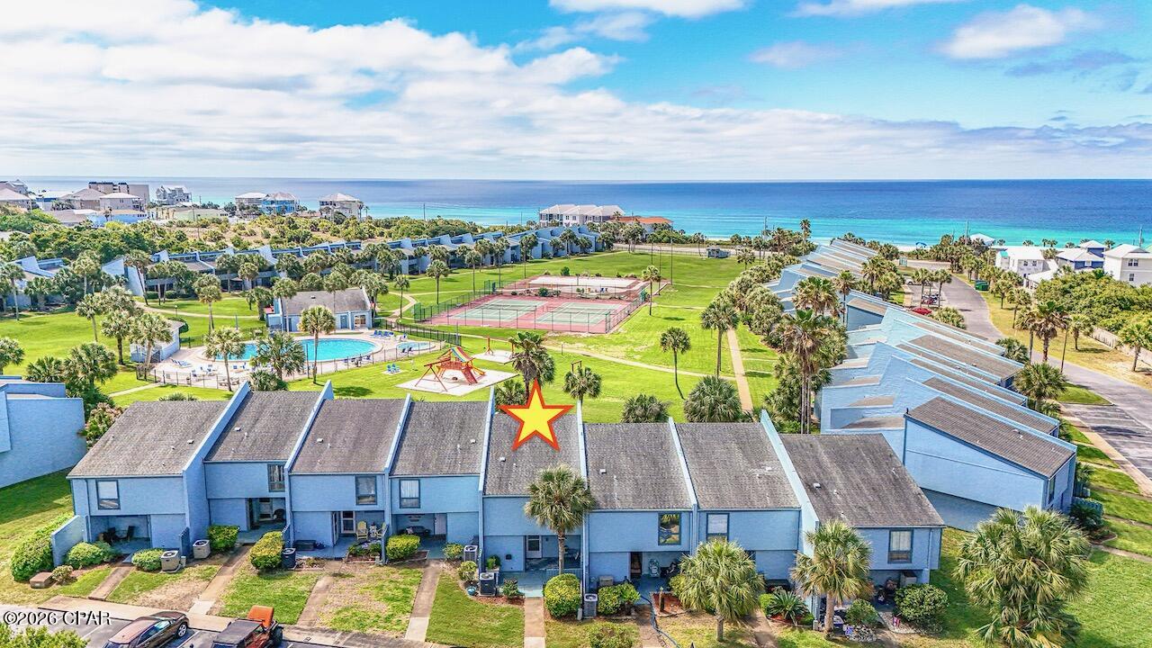 350 FEET OF PRIVATE BEACH JUST FOR YOU!  This incredible Sunnyside condo sleeps 10! These rarely come on the market, especially with a dedicated beach with private gazebo/viewing area to relax and enjoy the sunsets! This updated unit is 4th from right on bottom of ''U'' with wide panoramic view of the green! Situated amidst lush greenery, this tropical paradise encompasses 18 acres with 350 ft. of private emerald colored Gulf waters and sugar white sand beaches! The unique quality of this resort is the dedicated beach access. The underpass is a well-lit tunnel under Front Beach Road which leads to the large gazebo and boardwalk that sits on the white sandy beach! Only a short walk from your condo! 

Seller's thought this was their forever home so it was never used as a rental! This fully renovated unit has new lighting throughout, kitchen has custom tile backsplash w/ 15'' deep solid wood white cabinets w/ soft-close/deep drawers w/ dove-tailing combined w/ a beautiful quartz countertop. Custom solid wood beadboard added on adjacent wall to blend w/ existing. Deep stainless steel sink w/ dimmable light above, newer dishwasher, custom pots & pans drawers, too! Custom painted in 2024 w/ upgraded scrubbable paint & 6'' baseboards added! Stairwell updated in 2024. All doors and windows are solid wood trimmed. Condo faces South to get full light all day. Back wall has 90% UV protection screens even tho the sun does not beam in. Nice sized LR with queen sofabed and enough room to add an extra chair. The 16' high ceiling adds so much room to this already nice sized condo! Don't miss the high tongue and groove solid wood ceiling! Spectacular feeling when entering! DR seats 6 with a bench that can be added for extra guests! 1/2 bath downstairs with new cabinet and lighting. Laundry room behind it with full sized W/D. Laundry room exterior door is 36'' wide as is front door. Storm door added to enjoy fresh air.  Large walk-in owners closet. Nest thermostat. Loft area has a queen Murphy bed with beams above to blend with LR area. Some electrical outlets moved for convenience. Large Primary BR with wood beams and bottom up/top down custom shades as well as ensuite bath with updated tile shower. Guest BR has white solid oak single bunk beds with queen bed with custom storage cabinets above closet. Some units have the Guest BR with glass windows looking into the LR - this room is private! Also extra cabinet storage space in hallway.  New thick carpet in bedrooms w/ upgraded padding. Both baths are renovated w/ new lighting, tile flooring, vanity cabinets w/ soft close drawers.  Guest bath has bathtub/shower combo. Patio in front for relaxing as well as large patio out back to enjoy the incredible view! There is 24-hour service available daily whether it be maintenance or office manager on site. Security guard on site throughout the week. The HOA maintains the outside painting & roof, with internet, trash and water included. Sunnyside Beach & Tennis Resort is a tranquil escape located on the quiet WEST side of PCB. The complex amenities include: tennis courts, shuffle board courts, 2 pools (one for the little ones), a playground, and a clubhouse which features: free Wi-Fi connectivity, ping-pong table, and pool table and its very own private view of the Gulf. Come see this gem of a condo!  Make it your home! No RV parking, only boat trailers and enclosed trailers, maximum 30' located in private lot beside condo. (Some personal knick knacks do not convey and some items in pictures were used for staging)
