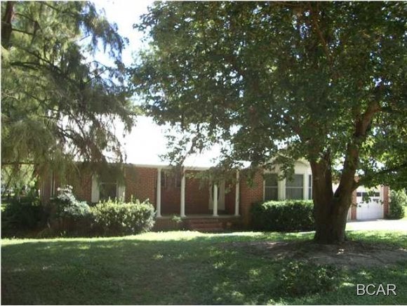 All brick home with vinyl trim and a detached garage with workshop on a corner lot in central Bay County. The setting is convenient, central to town, and yet serene. This home offers three large bedrooms, a family room with fireplace and insert, a huge living/dining room, plus a bonus room upstairs. There is also a walk around attic with walk-in access on the second floor with approximately 1000 sq. ft. of storage space. The detached brick garage with workshop was built in 2005 and measures 26' x 30'. The garage door is 10'x 12'; the roof is constructed with scissor trusses and has 14' of clearance. The home is on public water and also has a shallow well. Home is on a septic system, and the sewer tap fee is already paid allowing for an easy switch to public sewer. Bathrooms have