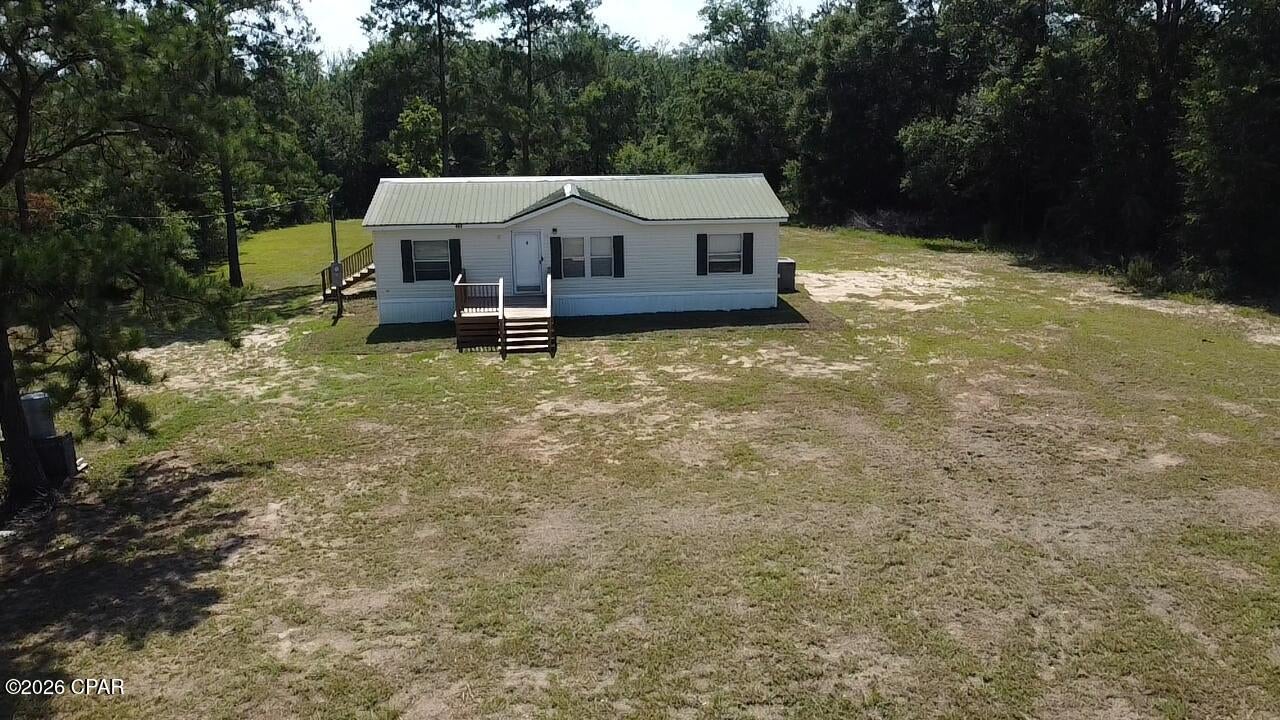 Peaceful Country Living on 1.56 Acres!

If you're looking for privacy, comfort, and convenience, this beautiful double-wide mobile home is a must-see! Situated on 1.56 mostly cleared acres in the southern region of Jackson County, Florida, this property is bordered by a large timber tract on two sides, providing a peaceful setting with plenty of privacy.

Step onto the spacious, welcoming front porch--the perfect place to enjoy your morning coffee or relax while taking in the quiet country surroundings.

Inside, you'll love the large open-concept living area featuring a desirable split-bedroom floor plan. The spacious kitchen offers an abundance of cabinet space, making meal preparation and storage a breeze.

The private owner's suite is located on one end of the home and features a large walk-in closet along with an ensuite bathroom. On the opposite end, you'll find two additional bedrooms and a generously sized guest bathroom, creating the ideal layout for family or visitors.

Recent updates include:

- New tile flooring in both bathrooms
- New vanities and toilets
- New hot water heater
- New stainless steel range
- New stainless steel microwave

The property is mostly level and cleared, with a gentle slope toward the wooded area in the back, offering plenty of space for outdoor activities, gardening, or simply enjoying nature.

Conveniently located just 10 minutes from Marianna and approximately 45 minutes from Panama City, you'll enjoy the tranquility of country living while remaining close to shopping, dining, schools, and the beautiful Gulf Coast.

Don't miss this opportunity to own a move-in-ready home with acreage, privacy, and a fantastic location!