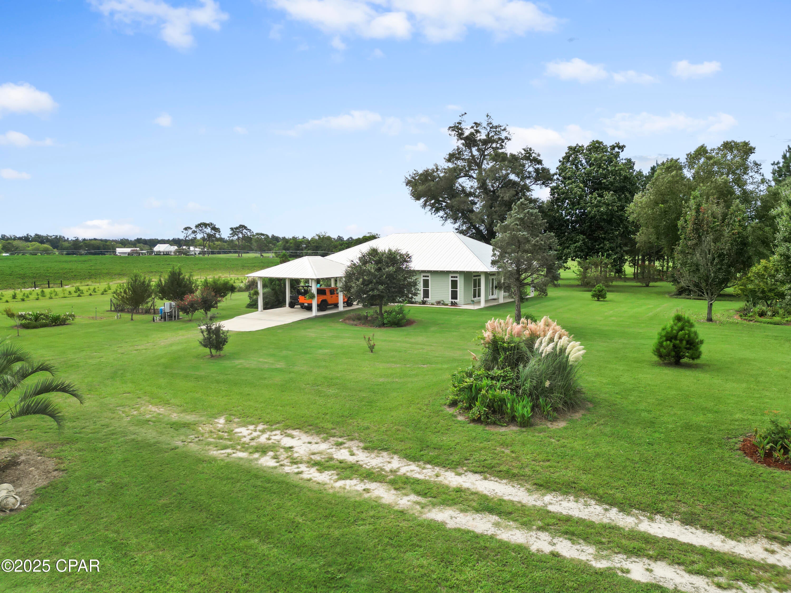 Custom-designed and built Country Estate on 16.75 m/L acres. This newer home built in 2020, features 2000 sq ft of living space (2920 sq ft under roof), with expansive porches and a detached 2-car carport. There is a sitting platform (ready for a hot tub or fire pit), with electric and water, that is beautifully landscaped to enjoy year-round serenity. The land is planted with Loblolly pine trees double rows 45-50 ft apart, to allow for grazing or hay production with an income potential in the future and additional privacy. 

The home is built to the new hurricane standards with 2x6, 10 ft. walls, 6 ft windows throughout with transoms, low-e tempered glass, Hardi board siding, metal wind-resistant hip roof, and energy-efficient spray foam insulation. Other interior features are 8 ft interior doors, luxury vinyl plank flooring, and a spacious open floor plan. The current Den could easily be converted to a third bedroom. 

The fully landscaped yard has an in-ground irrigation system in the front yard and behind the house. The porches have new, concrete skid-resistant custom color paint flake coating epoxy finishes applied by Deese Elite Custom within the last 6 months.  

There is a garden location that has well established Navajo thornless blackberries and peach trees. There are water lines running to numerous locations at the barn/shop and into the pasture area. 

Conveniently situated to the home is an expansive red steel building with a 400 sq ft. apartment or office and a 20x30 enclosed shop with double roll-up pass-through doors and concrete flooring. The office has a full kitchen, bathroom with shower, a fold down queen size murphy bed with side cabinet storage, and an inviting covered front porch to enjoy the full view sunsets. 

The property's premium location is just minutes (via paved road access) to Marianna Florida, or about 25 minutes to Dothan, Alabama, or about an hour away to Panama City. There is an additional 9.25 acres available for a total asking price of $679,000.

The county estate is suitable for horses and other livestock. The land is zoned one home per acre and has no deed restrictions.