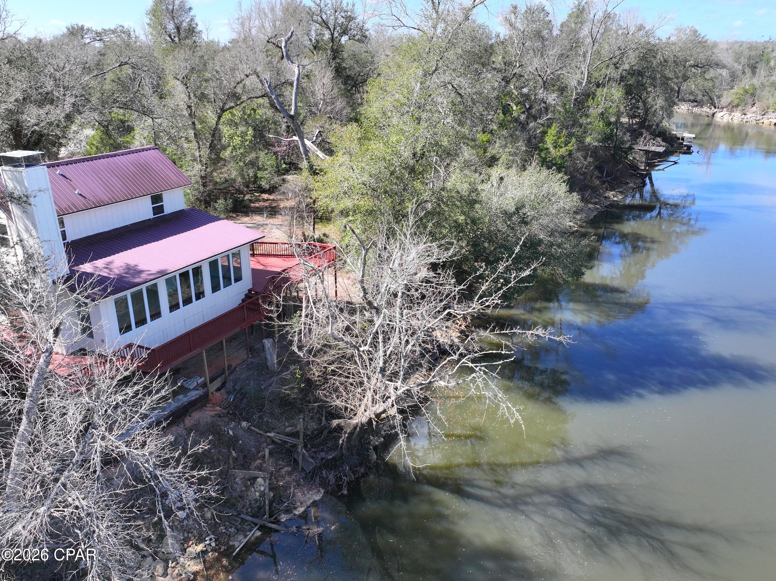 100 FRONT FOOT RIGHT ON THE CHIPOLA RIVER. 3BR/2.5 Baths, Over 1000 sq ft of decking overlooking the river. Experience the perfect blend of riverfront living, modern updates, and endless potential at 13770 NW Shuman Ferry Road. Boasting 100 feet of frontage directly on the beautiful Chipola River, this 3BR/2.5BA home offers breathtaking waterfront views and over 1,000 square feet of decking overlooking the river -- the ideal setting for relaxing, entertaining, or simply enjoying the peaceful surroundings.

The home has undergone extensive remodeling with upgrades throughout, including all-new windows, updated interior finishes, flooring, fresh interior and exterior paint, stylish light and plumbing fixtures, an electric fireplace unit, and updated kitchen appliances. The kitchen also features beautiful butcher block countertops and a versatile stove with conventional oven, convection, and air fry capabilities. Additional improvements include a new drain field and much more.

Plenty of storage space is available, including an unfinished area that could easily be transformed into a guest apartment, a private home office, hobby room, workshop, or additional living space -- offering incredible flexibility and added value. Whether you're looking for a full-time residence, vacation retreat, or investment opportunity, this riverfront property delivers comfort, charm, and room to make it your own. Be sure to check out the photos to truly appreciate everything this unique property has to offer.