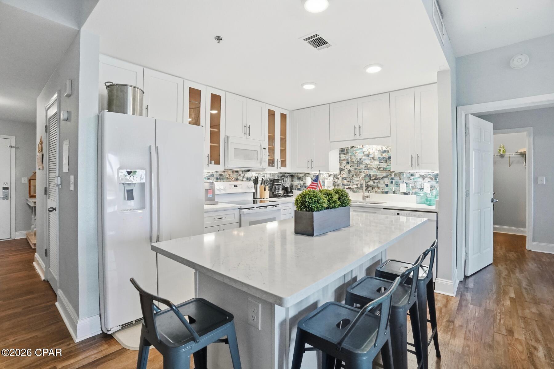 This exceptional first-floor residence offers the best of both worlds: calm lake views and easy access, all without the wait or hassle of elevators. From the moment you step inside, the coastal design and sophistication set this unit apart.

The beautifully updated kitchen is a true showpiece, featuring crisp cabinetry, upgraded countertops, modern appliances, and a striking turquoise backsplash bringing the Gulf's colors indoors. The open-concept living and dining space is light-filled and inviting--perfect for entertaining or unwinding after a day at the beach.

This unit offers two spacious bedrooms plus a stylish bunk room, ideal for guests or family. With the addition of a barn door, the bunk room easily functions as a third bedroom offering privacy, adding flexibility and value. The primary suite is a peaceful retreat, positioned directly on the lake with soothing water views that make mornings and evenings feel extra special.

Step out onto the large private balcony spanning the width of the unit to enjoy lake life and take in the nightly light show, visible both outdoors and from the comfort of the living area inside.

Beautiful design touches flow throughout the home, blending coastal charm with modern comfort. From the furnishings to the finishes, every detail reflects the essence of the perfect beach getaway.

Whether used as a primary residence, second home, or investment property, this first-floor unit with water views is a rare opportunity--where beauty, convenience, and coastal elegance come together seamlessly. 

As part of a large resort, you'll have access to world-class amenities, including the newest addition of 810 Billiards & Bowling as fun for the whole family on property, five pools (one zero-entry, heated, and a dedicated kiddie pool), two hot tubs, a state-of-the-art fitness center, and a putting green. Enjoy the convenience of multiple onsite dining options and a boardwalk that showcases a stunning nightly water fountain light show. Don't miss this opportunity to own a piece of paradise with solid rental returns and endless coastal charm! All measurements to be verified by buyer if deemed important.
