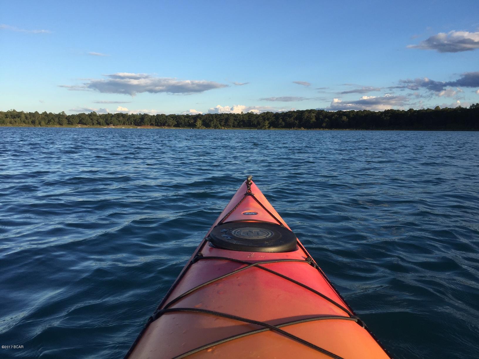 Waterfront! For a weekend getaway or homestead, the security gated community of Leisure Lakes offers relaxation and family fun. Just north of Lynn Haven, this subdivision has two lakes just right for swimming, kayaking, boating, fishing or bird watching. The pavilion area has a swimming pool, boat launch, toddler playground, tennis court, basketball court, restrooms, exercise room, a rental kitchen and more. This lot is located on the east side of the lake that makes for some wonderful views of the setting sun. Call today and come see for yourself. There are security guards weekdays, and a private code to enter the subdivision when guards are not present. Don't settle for less!