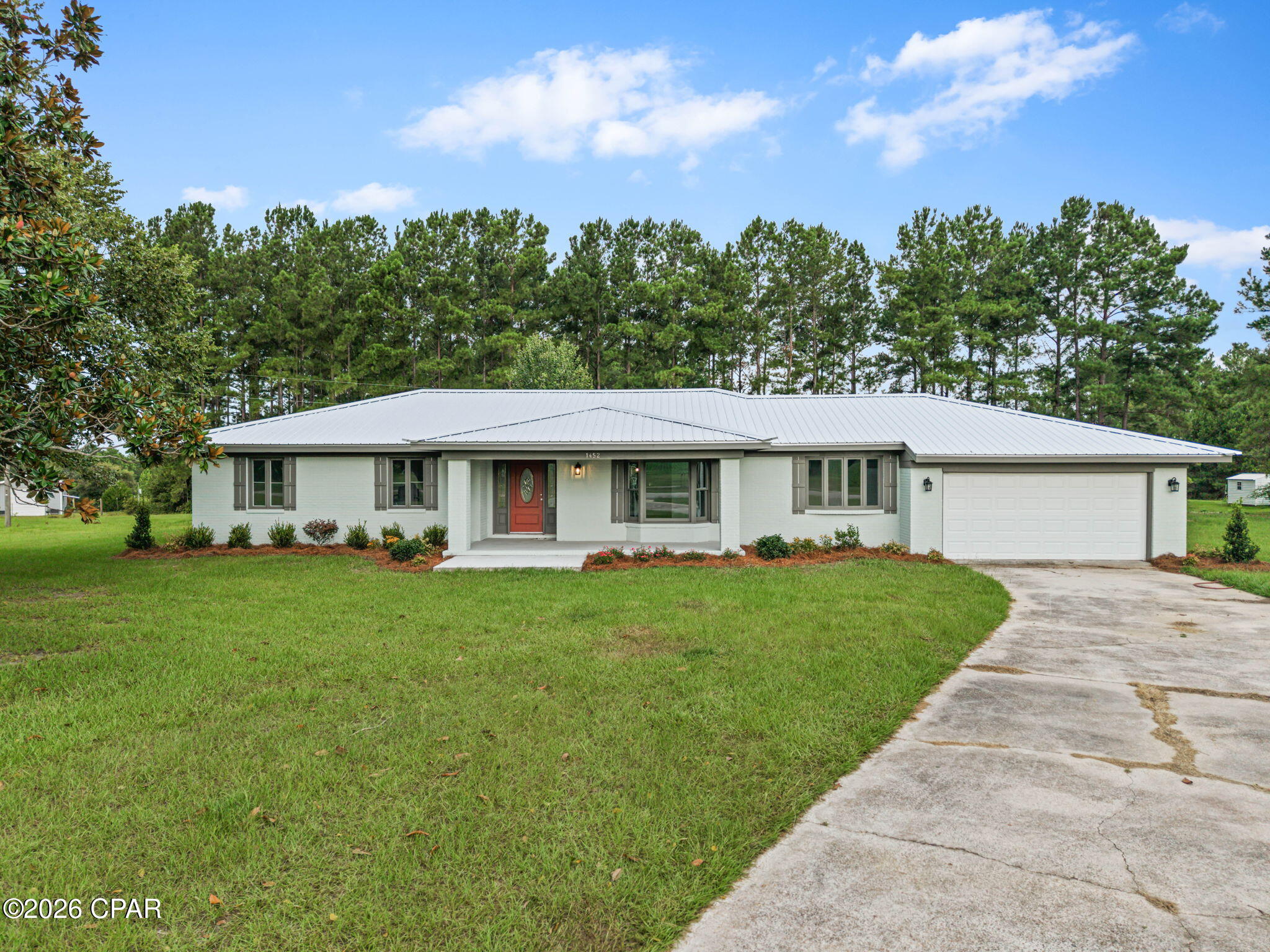 Coastal Farmhouse Charm Meets Modern Living on 2.29+/- Acres! Just north of Bonifay, this newly renovated 3 bedroom, 2 bath coastal farmhouse offers the perfect blend of timeless style, modern updates, and peaceful country living. Step inside to an inviting open floor plan featuring luxury vinyl plank flooring, fresh neutral finishes, abundant natural light, and oversized living spaces designed for both everyday comfort and entertaining. The stunning kitchen boasts white shaker cabinetry, generous counter space, stainless steel appliances, a large breakfast bar, and additional built-in storage that provides exceptional functionality. The spacious primary suite offers a relaxing escape with an updated ensuite bath featuring a walk-in shower and stylish finishes, while two additional bedrooms and a beautifully renovated guest bath provide comfortable accommodations for family and guests. Outside, you'll enjoy a welcoming covered front porch and rear deck overlooking the backyard, with plenty of room to spread out on the 2.29+/- acre property. The oversized attached garage offers ample storage and workspace, while the expansive yard provides endless opportunities for gardening, recreation, or simply enjoying the quiet country setting. A durable metal roof and freshly updated exterior complete this move-in-ready home. Conveniently located just minutes from Bonifay while offering the privacy and space you've been searching for, this coastal farmhouse is ready to welcome you home.