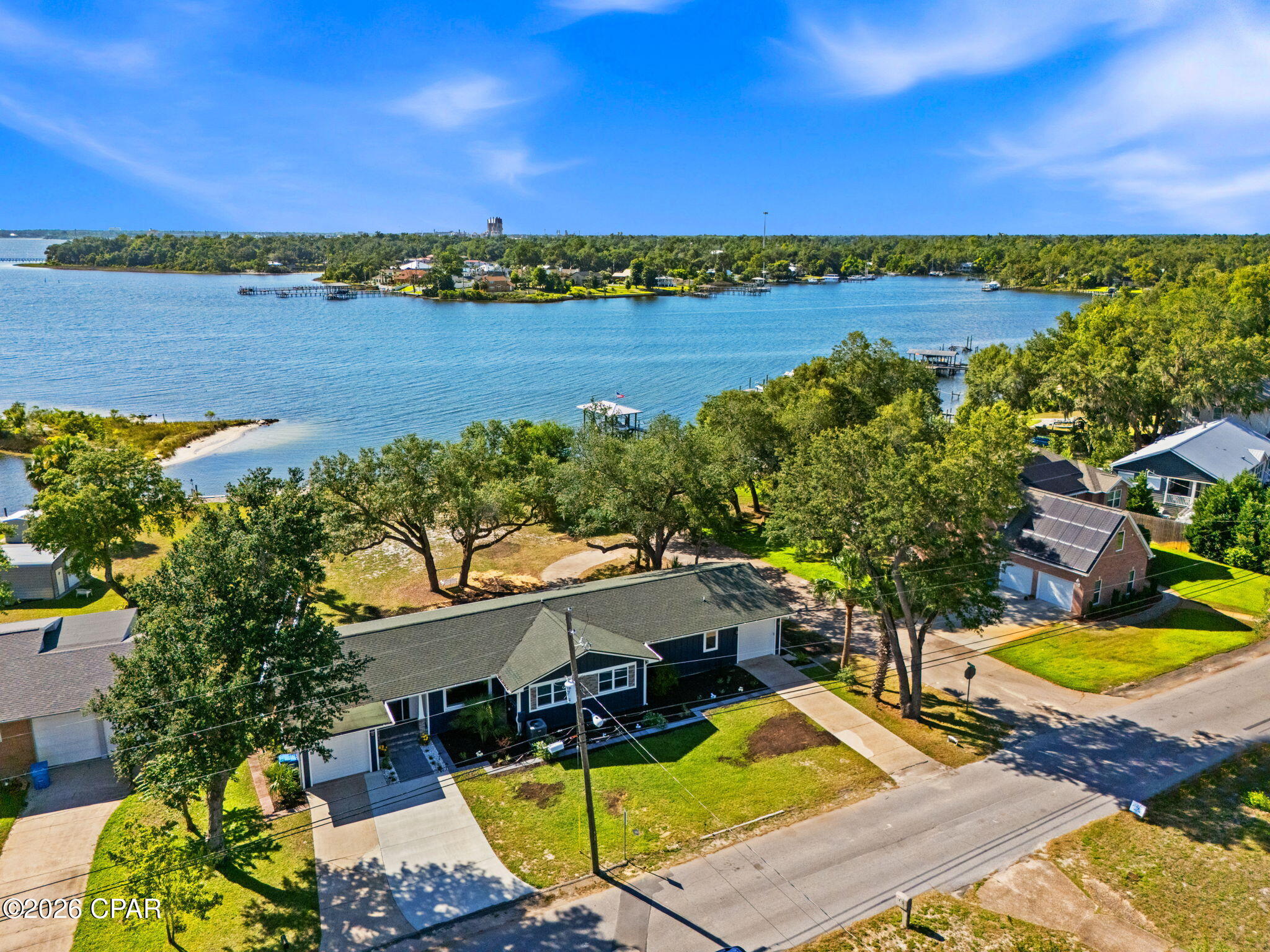 Stunning Deep-Water Retreat --> Fully Reimagined with Gulf Access
Tucked onto approx. 65' of water frontage with direct deep-water bay and Gulf access, 1440 Dover Road is a rare blend of craftsmanship, flexibility, and waterfront living. Originally built in 1950, this two-story home has been extensively remodeled and thoughtfully updated throughout; floorplan restructured, new electrical and plumbing, tankless water heater, whole-house filtration system, windows, and Hardie board siding, just to name a few. The home features durable concrete block exterior construction with a stick-built interior. In the main-level showers and floors, you'll even find premium epoxy grout (waterproof, stain-resistant, and mildew-proof). The roof and seawall have also been replaced.
Spanning 3,602 square feet, the home offers 4 bedrooms and 3.5 baths across two distinct living levels. The main level features a remodeled kitchen with granite countertops, stainless appliances, under-cabinet lighting, an open living and dining area, and a generous primary layout. Original red oak hardwood floors, refinished in a soft gray tint, bring timeless character with a fresh, modern feel throughout. The main level opens to a deck with a breathtaking view of the bay.
The lower level lives like its own private retreat: a second full kitchen with butcher block countertops, family room, a fourth bedroom, additional laundry room, full bath, and its own one-car garage. It can be reached by the interior staircase or, completely independently, from its own private entrance at the back of the property -- with a dedicated driveway and garage. This level offers convenient single-level, step-free living -- no stairs throughout (just a small lip at the entry) and a curbless, zero-entry shower -- making it ideal for multi-generational living, guests, or a private in-law or guest suite. There are also two attached one-car garages on the main level.
Set on just over half an acre (0.57) in an established, water-oriented neighborhood, and located in Flood Zone X (outside the special flood hazard area), a meaningful advantage for waterfront buyers. Convenient to schools, shopping, Tyndall AFB, and only 15 miles from the Naval station.
With a newer seawall and stairs leading right into the water, this property puts deep-water living within easy reach. Homes with this combination of quality, space, and true deep-water access don't come along often. This home is waiting for your dreams and memories to be made here.