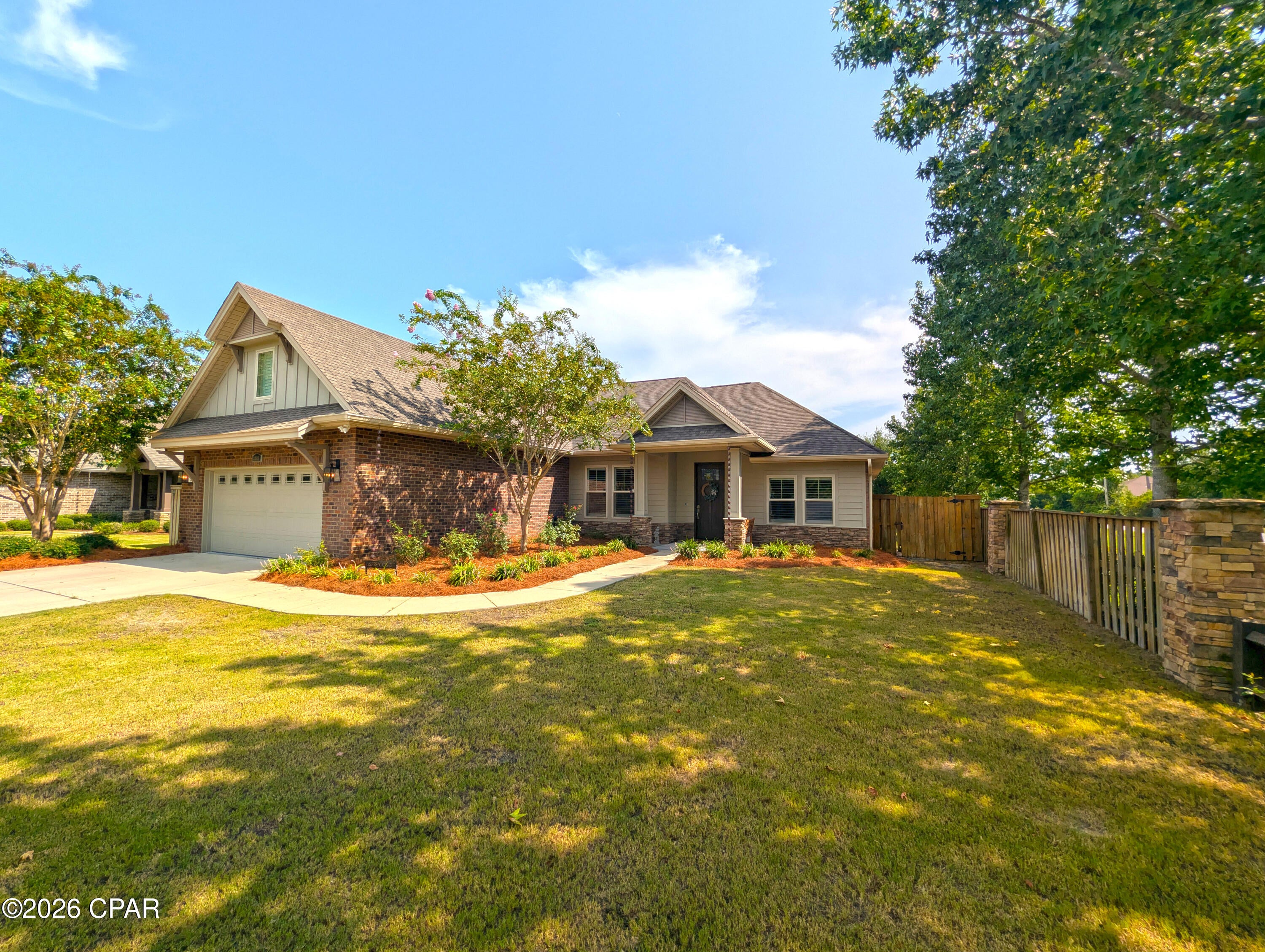Craftsman elegance meets modern convenience in this stunning 2017-built home situated on a manicured lot in Osprey Cove. Featuring high ceilings, crown molding, custom board-and-batten wainscoting, and durable wood-look tile flooring, this open-concept layout is designed for effortless everyday living and entertaining.
At the center of the home is a gourmet kitchen boasting quartz countertops, light gray shaker cabinetry, a mosaic tile backsplash, stainless steel appliances, and an expansive island with pendant lighting and breakfast bar seating. The kitchen opens seamlessly into a bright dining area and an airy living room, anchored by an electric fireplace with a stacked-stone surround and custom mantel.
The main-level primary suite is a private retreat with a tray ceiling, recessed lighting, plantation shutters, and a spa-inspired en-suite bath featuring a double vanity, walk-in shower, and deep soaking tub. Three additional guest bedrooms and full baths reside on the main floor. Upstairs, a flexible bonus loft with its own full bathroom and closet serves as a 5th bedroom, media room, or private office.
Thoughtful custom upgrades set this property apart, including a cozy under-stairs pet retreat with a TV mount, a wall-mounted smart home control center, plantation shutters, and a finished 2-car garage with epoxy flooring. Exterior features include brick veneer and HardiePlank siding, stone-accented perimeter fencing, mature landscaping, and a fully fenced privacy backyard.
Key Features & Upgrades
Gourmet Kitchen: Quartz countertops, mosaic backsplash, stainless appliances, light gray shaker cabinets, and an oversized island.
Living & Interior Details: Wood-look tile flooring, crown molding, board-and-batten wainscoting, stacked-stone fireplace, and wall-mounted smart panel.
Main-Level Primary Suite: Tray ceiling, recessed lighting, double vanity, walk-in shower, and garden tub.
Bonus Spaces: Under-stairs custom pet nook, second-story media loft with full bath, and epoxy-coated garage.
Exterior & Yard: Brick and stone accents, HardiePlank siding, fully fenced backyard, stone pillar fencing, and lush curb appeal.