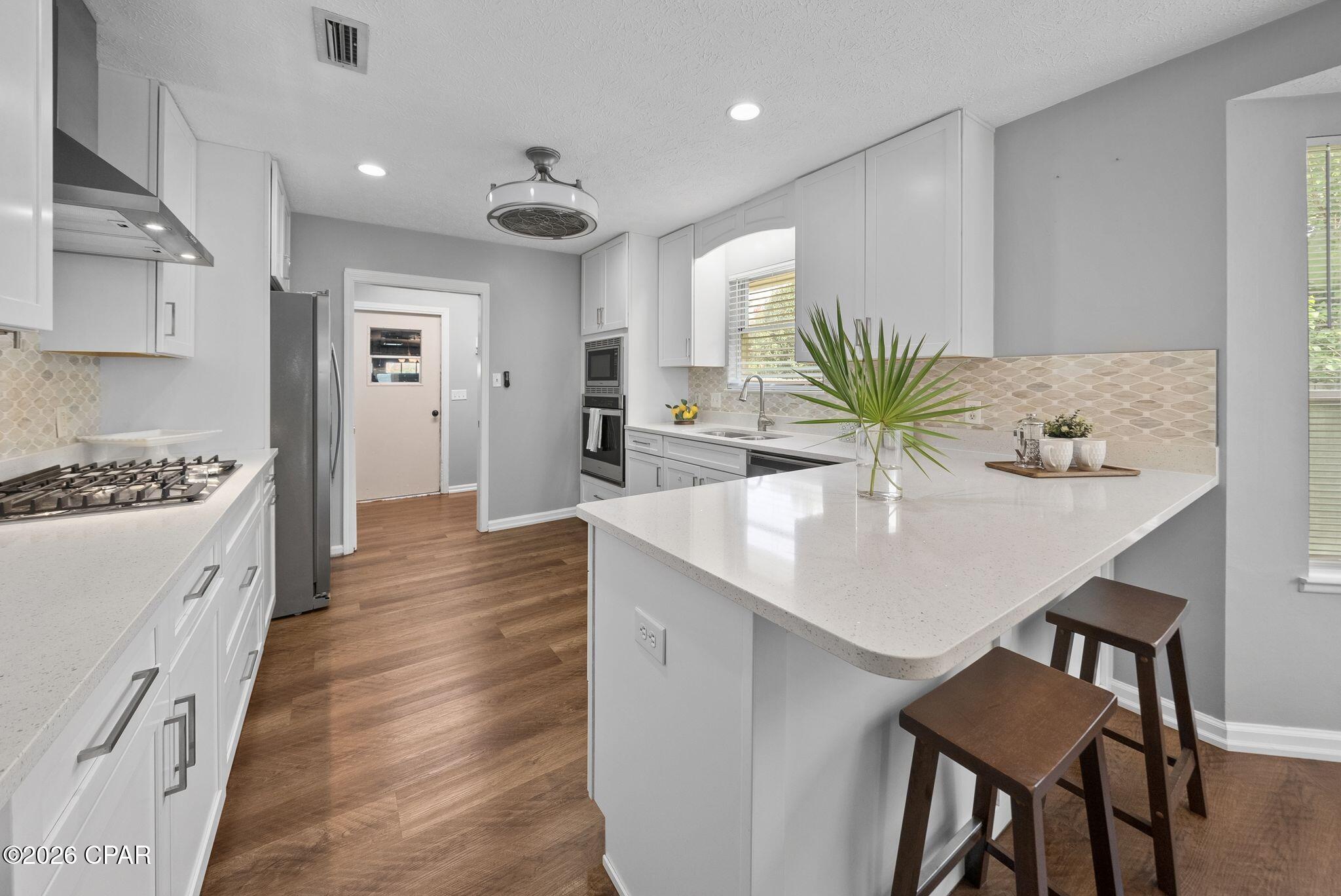 CURRENTLY UNDER CONTRACT, SELLER WILL CONSIDER BACKUP OFFERS. Tucked right in the heart of Lynn Haven, this is what NO HOA living is supposed to feel like! With four bedrooms, two baths, a spacious sunroom, two-car garage and room for a pool in the fenced backyard...this is an ideal layout nearing 2700 square feet.

You're minutes from Downtown Lynn Haven's walkable Main Street corridor, with its local restaurants, boutiques, and coffee shops, plus Sharon Sheffield Park for weekend farmers markets, food trucks, and the city's signature festivals and holiday events throughout the year in the ampitheater. Nature Walk Golf Course, Kaleidoscope Theatre, and Lynn Haven's A.L. Kinsaul waterfront park along the Bay are all in the neighborhood and this home offers quick access to and puts Tyndall Air Force Base, Naval Support Activity Panama City, and downtown Panama City well within reach.

Step inside to the vaulted, beamed spacious living area with a wood-burning fireplace that flows naturally to an open, fully renovated kitchen featuring white shaker cabinetry, quartz countertops, stainless appliances and a cozy breakfast room. The dining room is just off the foyer and is filled with light from the front of the home overlooking the charming courtyard. Luxury vinyl plank flooring runs through the main living spaces making it durable and updated for years to come. The fully renovated kitchen brings modern finishes together with a stainless gas cooktop, wall oven and built-in microwave and dishwasher. 
 
The home features four bedrooms and 2 baths and large closets. The best part of this home is the oversized climate-controlled sunroom. This space offers unlimited flexibility and is the ultimate flex space...playroom today, home gym tomorrow, home office or second living room whenever life calls for it. Decide to build a pool? This would be an incredible space off the pool to hang out overlooking the water.

A huge benefit to a Buyer on this home is that the solar panels will be fully paid off requiring no lease, no loan to assume and no additional cost. This benefit keeps the average electric bill around just $50 a month adding to the desire for this home over others in Lynn Haven! 

This home also features a gas water heater for efficiency for a larger family and a dedicated 220V outlet ready for EV charging. Outdoors, the fully-fenced backyard is ready for cookouts and letting dogs and kids play or just quiet evenings to yourself.

In the ''state streets'', of Lynn Haven, you're minutes from shopping, dining, dog parks, public boat ramps and activities year-round. With NO HOA, you're going to love that you can park your boat in your driveway, load it up at your own schedule and live the Florida life you've always dreamed of. This home is an incredible opportunity in a highly desirable area with all A-rated, top performing public schools that this home is zoned for. There's a reason people love Lynn Haven and there's a reason it was recently named TOP 10 places to live in Florida! 

This property is also eligible for 100% financing with USDA lending. Inquire for more information!