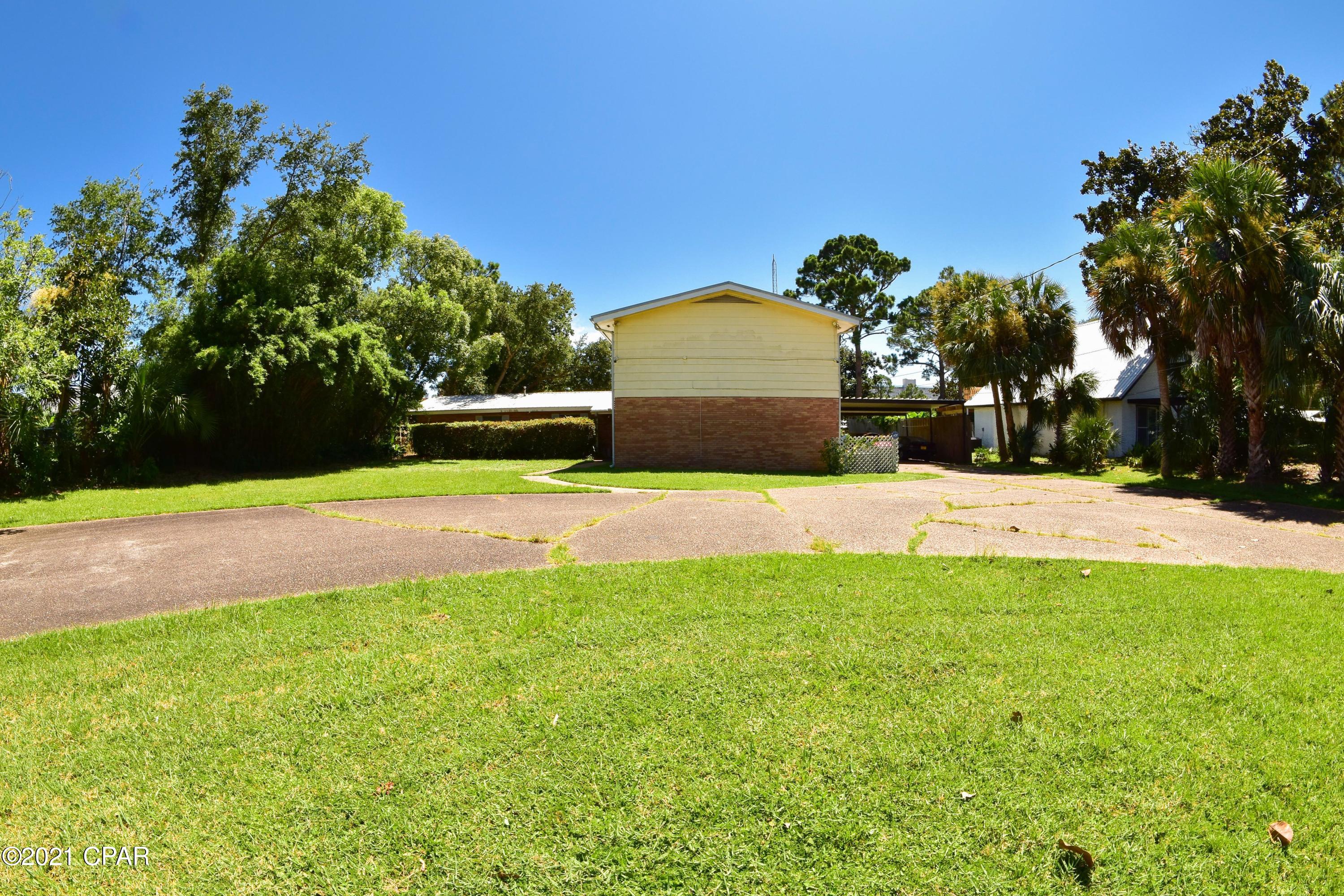 Over 100 feet of prime waterfront property on Grand Lagoon with a boat dock!!  This 3BR/3BA home sits on a double lot which is valued at over $700,000!  The home needs some updating but the bones are good & you'll love the layout!  The kitchen, family room, sun room, living room, laundry & 2  bedrooms & baths are on the 1st floor, while the 2nd floor consists of the master suite.  There is also an attached office space accessible from inside & outside the home for extra privacy. The back deck has a kitchen & a vine-covered pergola & is the ideal spot for enjoying the view & all the natural wildlife you're likely to see - dolphins, manatees - birds.  The lagoon was recently dredged to 12' and you can be on the bay and gulf with In addition to the circular driveway, there is a two car carport.  You're convenient to shopping, dining, schools and the beaches!  ALL info is approx and must be verified by Buyers if important.