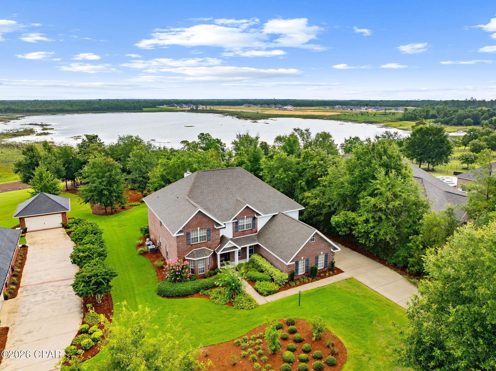 ASSUMABLE LOAN AVAILABLE WITH AN INCREDIBLE 2.25% INTEREST RATE!*

Rarely does a property offer this much space, privacy, and waterfront lifestyle in one package. Set on 1.14 acres with approximately 110 feet of frontage along the crystal-clear waters of Lake Merial, 147 Lake Merial Shores is a 4,182-square-foot waterfront retreat designed for those who believe home should be the gathering place for every holiday, celebration, and family milestone. Featuring six bedrooms, a bonus room, three-car garage and expansive indoor and outdoor living spaces, this remarkable estate is where unforgettable lake memories are made. 

From the moment you enter, soaring ceilings and beautiful hardwood flooring create an impressive first impression. To the left of the foyer, a stunning floor-to-ceiling custom library provides the perfect setting for a private office, reading retreat, or study. The private library showcases a custom rolling ladder that glides effortlessly along the entire room. Formal living and dining spaces offer flexibility for gatherings, while a dedicated dining room area with a private bar creates an inviting atmosphere for hosting family celebrations and holiday dinners. The grand living room serves as the heart of the home, featuring dramatic 18-foot ceilings and expansive windows that frame picturesque views of the lake beyond. A beautiful wood burning fireplace creates a warm focal point, flanked by custom built-in cabinetry that provides both elegant display space and functional storage while enhancing the room's timeless character. 

The well-appointed kitchen offers abundant cabinetry and storage throughout, including an extended custom storage area adjacent to the eat-in kitchen space. A conveniently located half bath near the kitchen enhances the home's thoughtful design and provides added comfort for guests during gatherings and special occasions. The spacious primary suite is located on the first floor, creating a private retreat separate from the additional bedrooms. 

Upstairs, you'll find five generously sized bedrooms, two full bathrooms, and a massive bonus room large enough to serve as a home theater, game room, fitness area, or recreation space large enough for a pool table. 

Step outside and experience the true beauty of Lake Merial living. Outdoor living takes center stage with a covered back patio and an expansive paver terrace designed for entertaining and relaxation. A private paver pathway meanders through the backyard to the lakefront, creating a seamless connection to the waterfront lifestyle. Whether you're launching a kayak, casting a line, or enjoying a sunset cruise, Lake Merial becomes an extension of your backyard. The meticulously maintained grounds create a park-like setting, offering plenty of space for outdoor entertaining, backyard barbecues, family gatherings, and making memories with friends and neighbors. Imagine spending Independence Day watching fireworks illuminate the lake, enjoying golf cart rides through the neighborhood, and ending the evening gathered around the water with family. 

Lake Merial is one of Bay County's most sought-after waterfront communities, centered around a beautiful 300-acre spring-fed lake known for its clear waters and year-round recreational opportunities. Residents enjoy community events, walking trails, green spaces, and food truck nights. 

Defined by its scale, waterfront setting, and enduring craftsmanship, this home stands as a distinguished Lake Merial residence, offering the space, privacy, and versatility to accommodate generations while creating an exceptional backdrop for everyday living. As one of only a handful of homes of this size situated directly on the water within Lake Merial, this remarkable property represents a rare opportunity to own one of the community's most significant waterfront estates.