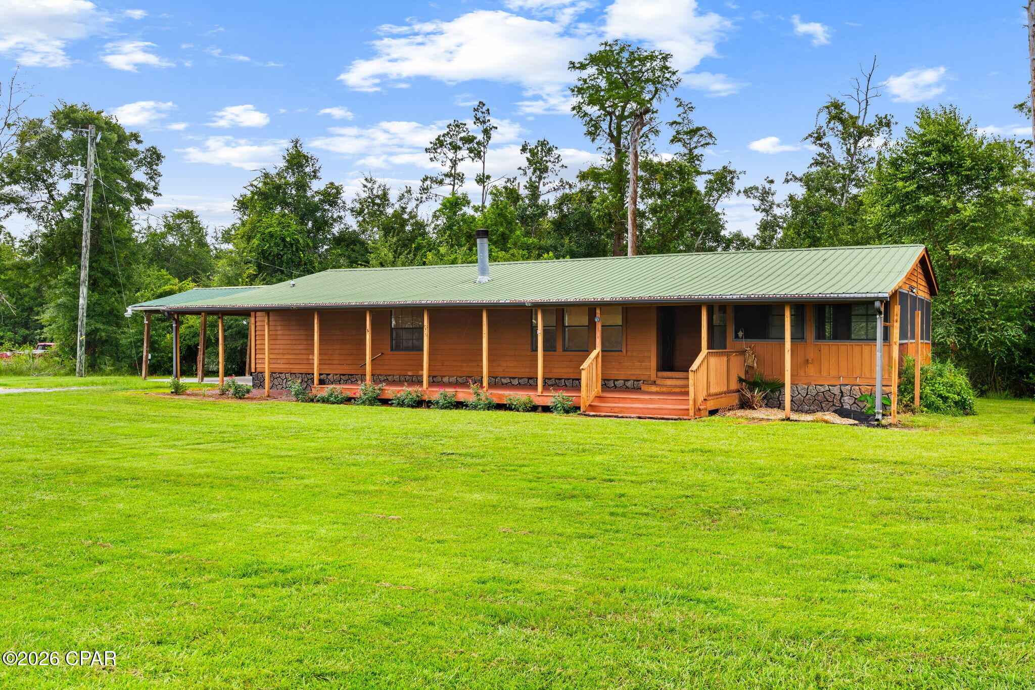 CURRENTLY UNDER CONTRACT, SELLER WILL CONSIDER BACKUP OFFERS

Welcome to 8306 Highway 2301 in Youngstown, where peaceful country living meets comfort and convenience. Situated on approximately 1.12 acres surrounded by mature trees, this well-maintained 2-bedroom, 2-bath home offers approximately 1,606 heated and cooled square feet with a functional, single-level layout and plenty of room to enjoy the outdoors.

This home has received several updates, including luxury vinyl plank flooring throughout and interior paint completed within the last three years. The home also features a Nest thermostat, allowing you to conveniently control the HVAC system from your phone, along with an owned Culligan water treatment system.

The inviting living room features a beautiful woodburning, white stone fireplace accented by a wood mantel, creating a warm and welcoming focal point. The spacious kitchen offers stainless steel appliances, a center island, and plenty of room for everyday living and entertaining.

Just off the kitchen, a sliding glass door leads to a screened porch overlooking the property's natural surroundings; the perfect place to relax and enjoy the peaceful setting. The home also features a large covered front porch (15 x 53), providing additional outdoor living space. The spacious primary suite features two closets and a well-appointed ensuite bathroom with dual vanities, a large soaking tub, and a separate walk-in shower.

Outside, the property includes a two-car carport and a separate storage building for added convenience. With approximately 1.12 acres, mature trees, and no homeowner's association, this property offers privacy, space, and the flexibility to make it your own.