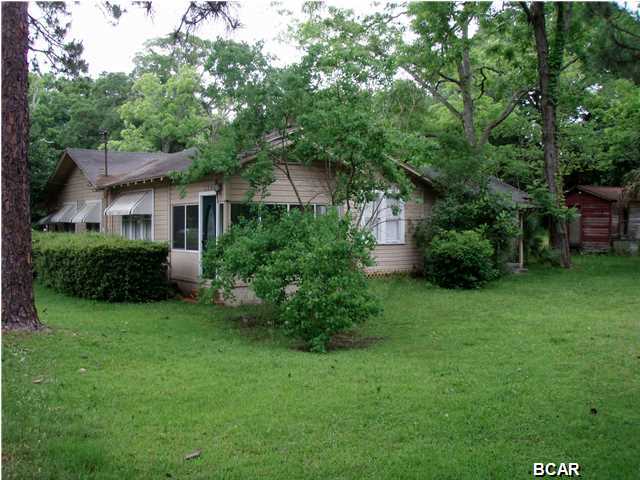 Lovely parcel .... 5 lots & over an acre of land! Home has been well maintained with lots of rooms. Living area has a wood buring fireplace and a beautiful enclosed front porch. There is an entry room for lounging and visiting as you enter from the driveway. The kitchen is equipped with a nice white refrigerator, matching white gas stove. There is enough room in the kitchen area to include an additional prep station or a table and chairs for in kitchen dining. The next area is a crossroads for the rest of the living spaces. This room would be ideal for informal gatherings and/or for a station for crafts, homework, games, or additional tables for large family get togethers. The living room with wood burning fireplace feels like a parlor of sorts, giving a more formal living room where