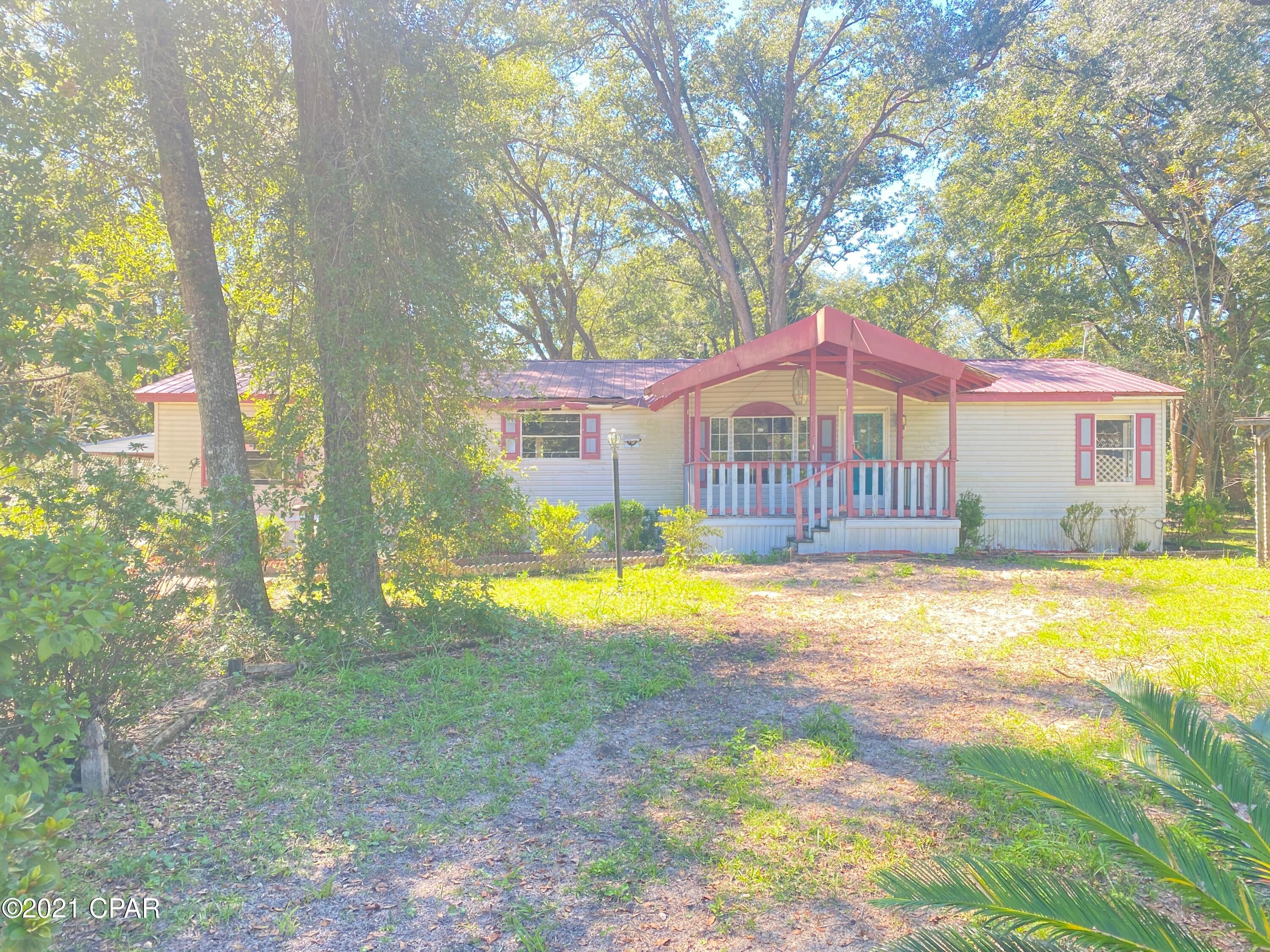 Large manufactured home on generous size lot. This home has covered front and back porches which extenuates the serene canopy feel under the large shade trees. There is a detached carport and workshop. The living room is huge and is complimented by a large family room with fireplace. While this home is in a country setting it is only about 40 minutes to the beaches. This property is now zoned for a commercial use.