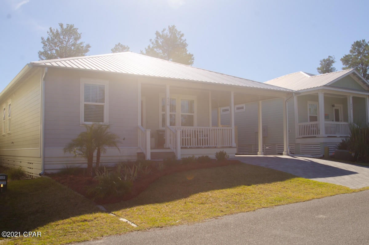 BEAUTIFUL, LIKE NEW Cottage Style home, less than half a mile from the beach and from the classic Thomas' Doughnuts in WEST PCB! 3 Bedroom, 2 bath, office with pocket doors, can be used as bedroom. Blinds throughout. A lot of sunshine coming through the house with all of the windows! Gated neighborhood, dog park and children's play area!! This home has been a vacation home and has been used sparingly! From the subway tiles backsplash to the enormous bathroom showers, you will look forward to coming home to this adorable cottage! From the covered front porch with double fans, relaxing back patio with outdoor shower, outdoor landscape lighting, sprinkler system, wi-fi controlled HVAC unit, attached storage, and walking distance to the community pool, you know this home will go quickly!