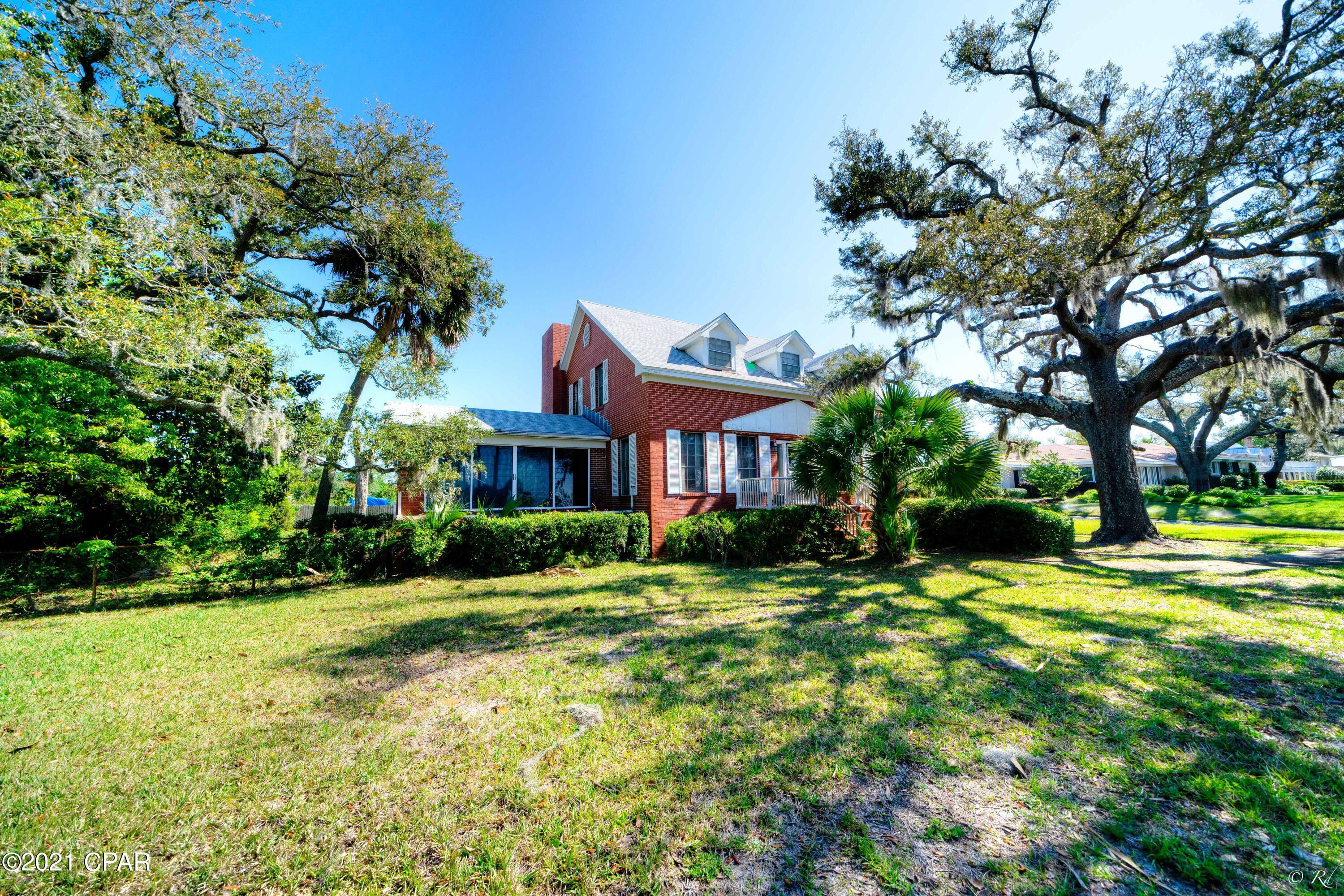 Location!! Bask in the gorgeous Florida sunsets settling over the Bay from the privacy of your own home and private beach! Wind down and watch the ships sailing through while enjoying views of Shell Island.  This 3 bed, 3 bath colonial style home is situated on a double lot on one of the most coveted streets in town, nestled among mature trees. This property leads all the way to the water, providing a peaceful and serene spot to create lasting memories with family and friends. This home will wow you with its space and character! The main floor of the home boasts a Florida room, den, kitchen and formal dining area with a fireplace. The main floor also features an office with faux fireplace and beautiful, bead board ceilings and walls. The Florida room has shiplap ceilings and sliding glass doors leading to the large backyard that is perfect for entertaining. There is also a screened-in side entrance. This home is one of the few homes in Florida with a basement. The basement is unfinished and gives a rare chance to start fresh, allowing your dreams of a man-cave, theater room, game room and more to come to life! The laundry area is also located in the basement. The third floor of this home hosts all 3 bedrooms and 2 bathrooms. The master bedroom features his and hers closets, built-in storage and a private master en suite. The master bathroom has a shower/tub combo with sliding glass doors and a vanity with a nook. The two additional bedrooms share a full bathroom with a shower and also has a vanity with a nook. This home needs work and is being sold as-is. The possibilities are endless with plenty of room for dreamy landscaping and gardening among the Oak trees. Although there are few ceiling stains, there are no leaks right now. The front of the roof is only 3 years old and the back of the roof is all brand new. The carport needs a new roof. As-is.
