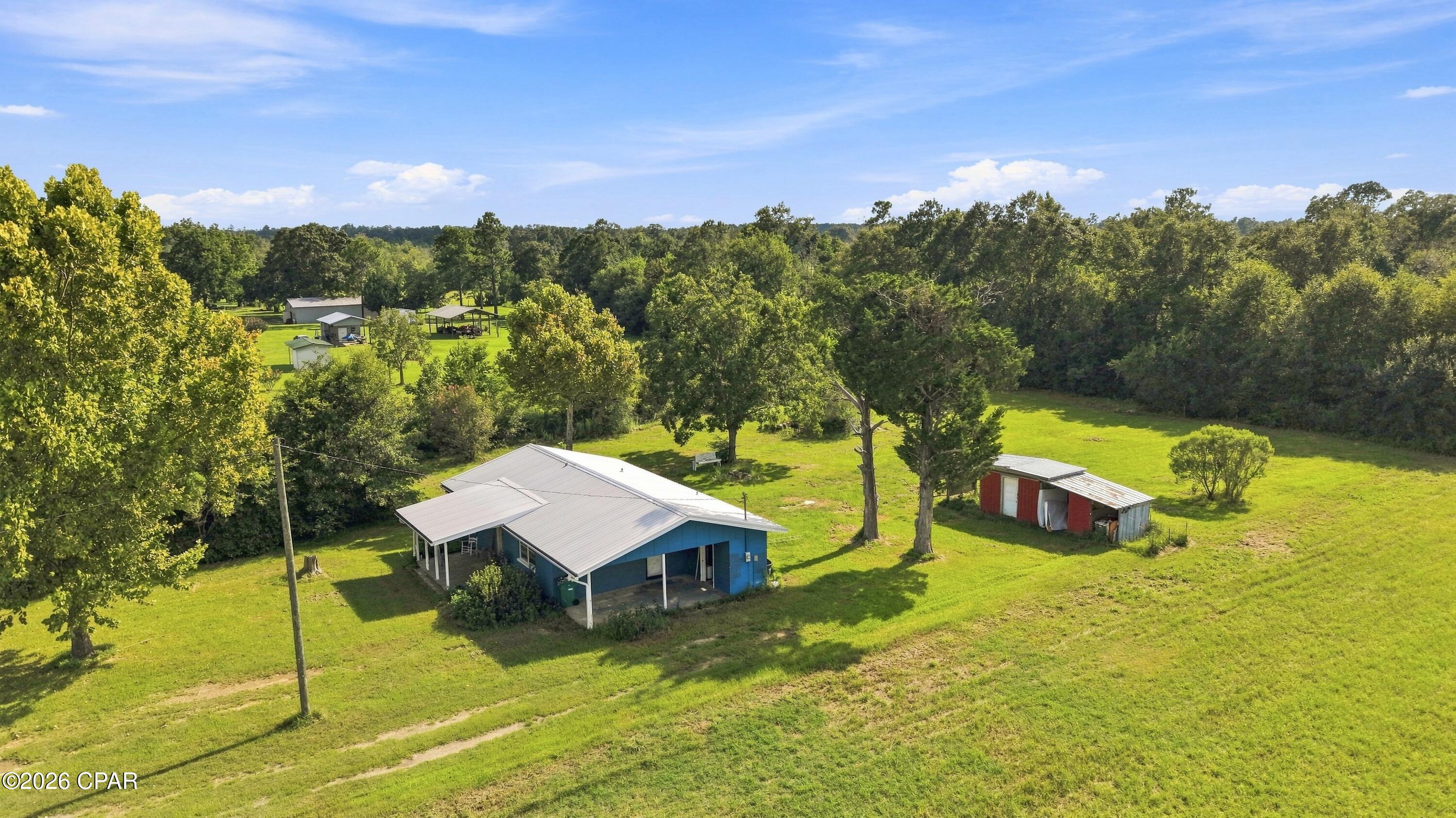 Country living, fully refreshed! Welcome to 972 Sewell Farms Road, where wide-open green space, mature oaks, and a rocking-chair front porch deliver the slower pace you've been searching for - without giving up a fully updated interior. This 3-bedroom home on 2 cleared acres with tasteful updates including vinyl plank flooring throughout, fresh paint, and crisp white cabinetry, granite-look counters, newer roof, and hvac .Outside is where this property shines: sip your morning coffee on the full-length covered front porch, fire up the grill on the covered back patio, and let the kids, garden, or animals spread out across two open acres framed by beautiful oak trees. A metal roof, attached carport, and a storage building with lean-tos on each side add practical value - and with no HOA, bring your RV, boat, and animals. All this just minutes from downtown Chipley and I-10, five minutes from Falling Waters State Park - home of Florida's tallest waterfall - and under an hour to the sugar-white beaches of the Gulf Coast. Whether you're a first-time buyer, downsizer, or investor, homes on acreage at this price don't last. Schedule your showing today!
