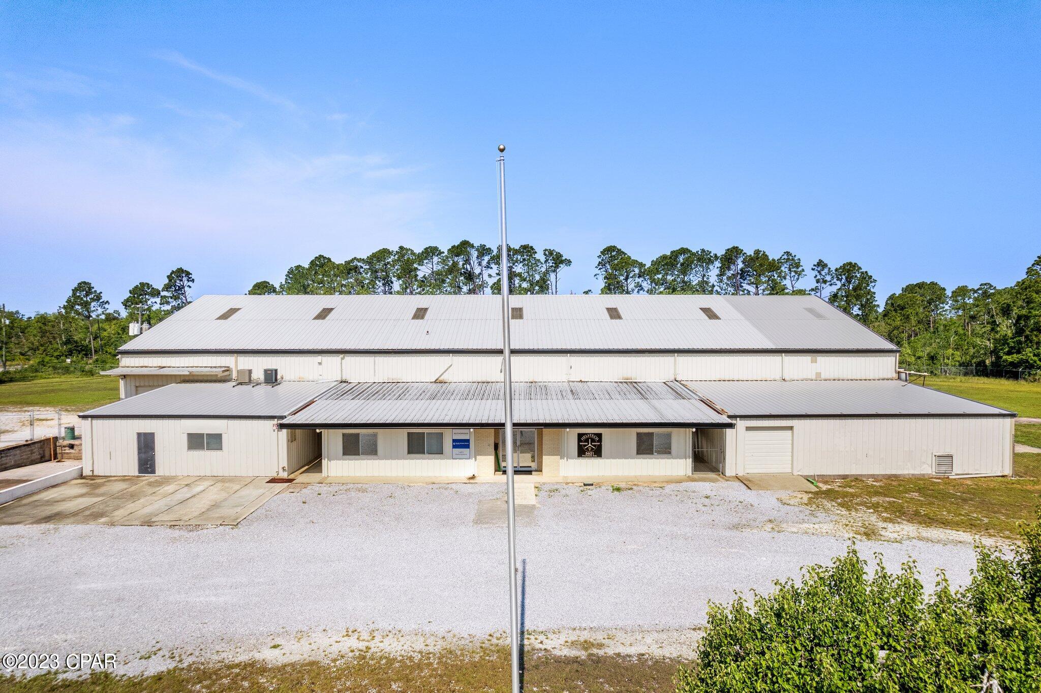 UNDER CONTRACT ACCEPTING BACKUP OFFERS Excellent corporate industrial site includes fenced acreage, steel warehouse and offices This is a 3.5 acre parcel within Panama City that is classified industrial property with a 19,476 sf building and helipad. The building has large doors on both ends. Possible property uses include: warehouse, defense contractors, suppliers, distribution, R&D, trades contractors, road work contractors, many possible uses with secure spacious yard. Features include: #1 40' wide x 20' tall opening. Center ceiling height 32'. #5 - 15' wide by 14' high bays. #1 15' wide bay x 9' high. #1-20' wide bay x 9' high. It has 3 phase 1200 AMP service with outstanding lighting and plumbed air lines. The warehouse has an open center with second floor mezzanines that have steel decks and capable to support storage. There are also two offices on the mezzanine. The entry has a reception area, multiple offices and break room.