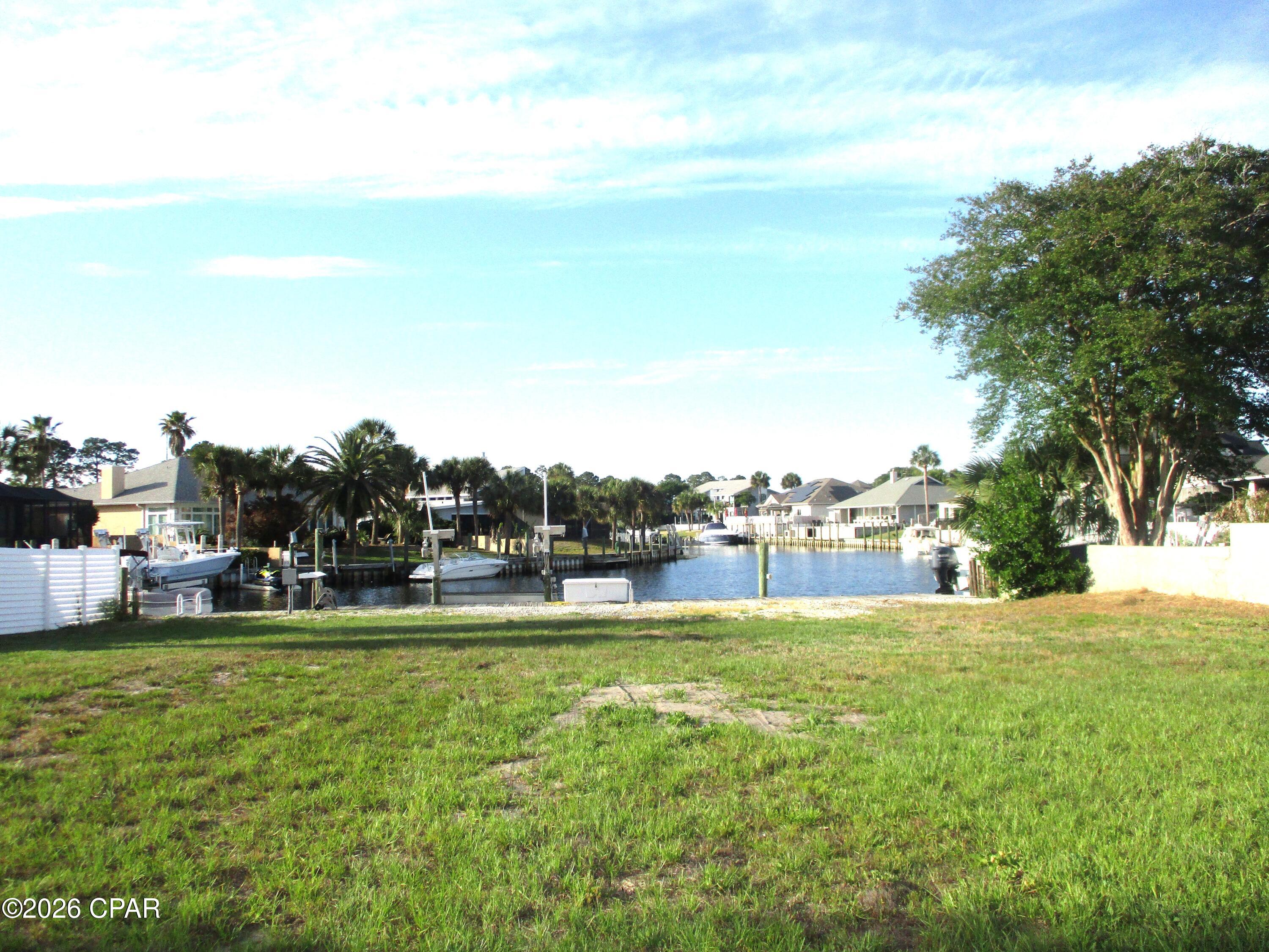 Water, power and boat lift already in place for you! Bring your boat now and build your dream waterfront home later!  This is one of the few remaining deep-water canal homesites available in the  gated community of Bay Point. Ready for construction, the property is already equipped with water, power, and a boat lift, saving valuable time and significant development costs. An added bonus is its ideal positioning, offering long, picturesque views down the canal rather than directly across, creating a more open and impressive waterfront setting. House plans are available, making it even easier to bring your vision to life. Enjoy direct deep-water access from your dock to the Gulf, whether you're heading out for a day of fishing, cruising to Shell Island, or simply enjoying life on the water. Bay Point is one of Panama City Beach's premier gated communities, featuring 24-hour security, a Jack Nicklaus championship golf course, a full-service marina, on-site dining, and beautifully maintained grounds. Conveniently located just minutes from St. Andrews State Park, Shell Island, shopping, restaurants, and the sugar-white beaches of the Gulf Coast. Rare opportunities like this don't come along often. Build exactly what you've been dreaming of in one of the area's most desirable waterfront communities. Seller is a Florida licensed real estate agent.