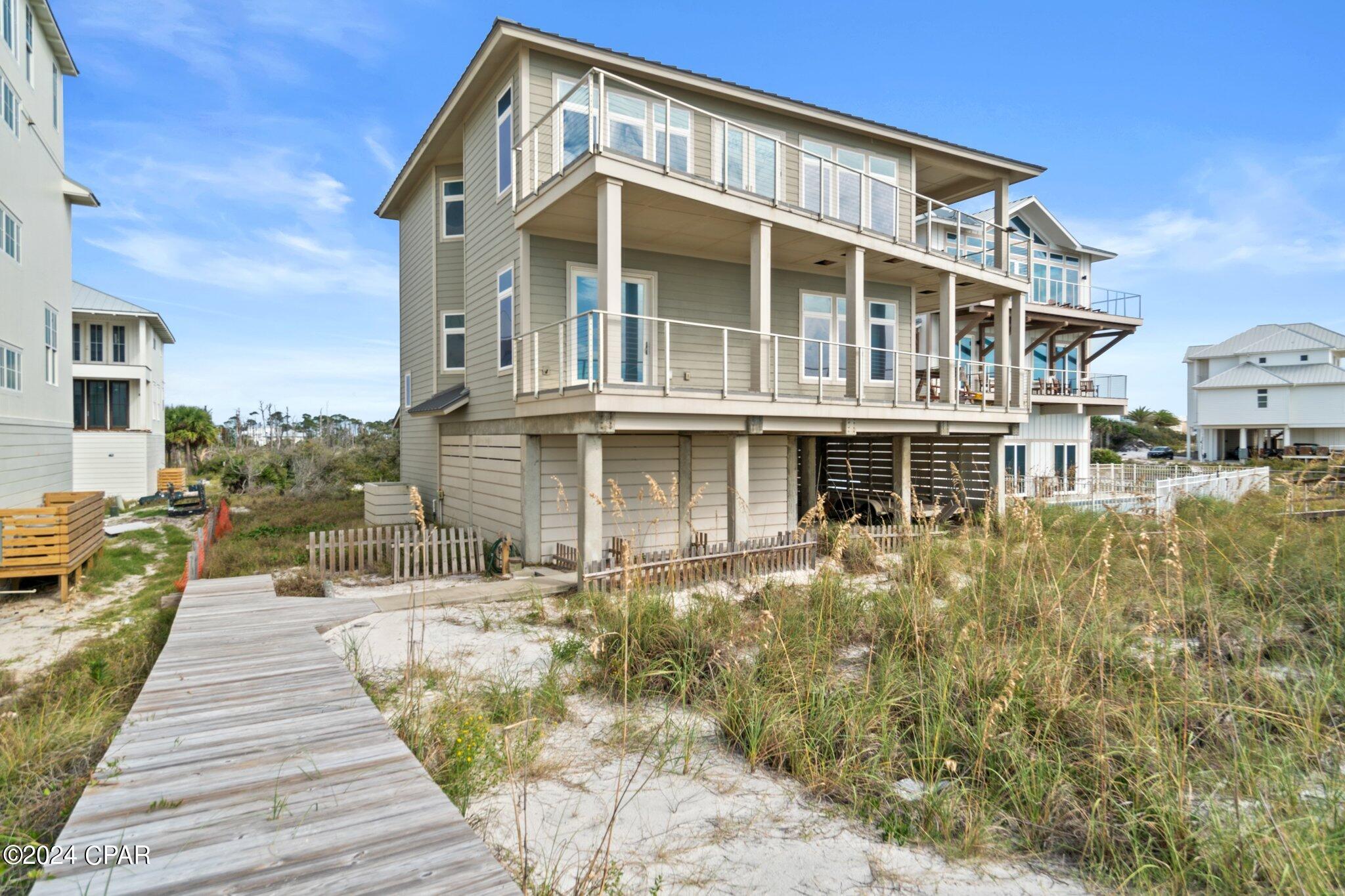 Wake up to the Gulf, step onto the balcony, and let the beach set the pace. 151 Sapodilla Ln brings together 4,068 sq ft, 5 bedrooms, 6 baths and a front-row Gulf setting on approximately 0.4 acres in Cape San Blas. Inside, the open floor plan keeps the water in view from the main living spaces, with oversized windows and doors pouring in natural light. The kitchen is ready for a crowd with stainless steel appliances, generous cabinetry, a spacious island and plenty of prep space. A striking wood-accented ceiling, wood and tile floors, stylish furnishings and coastal views give the home a polished yet relaxed feel. Multiple Gulf-facing balconies create inviting spaces for morning coffee, sunset conversations and salty-air lounging. An elevator makes moving between the two stories easy, while the carport and long driveway offer plenty of parking. Add a metal roof, spacious bedrooms, beautifully finished baths--including a freestanding tub and glass shower--and a community pool, and you have a compelling Cape San Blas getaway with second-home and vacation-rental appeal.