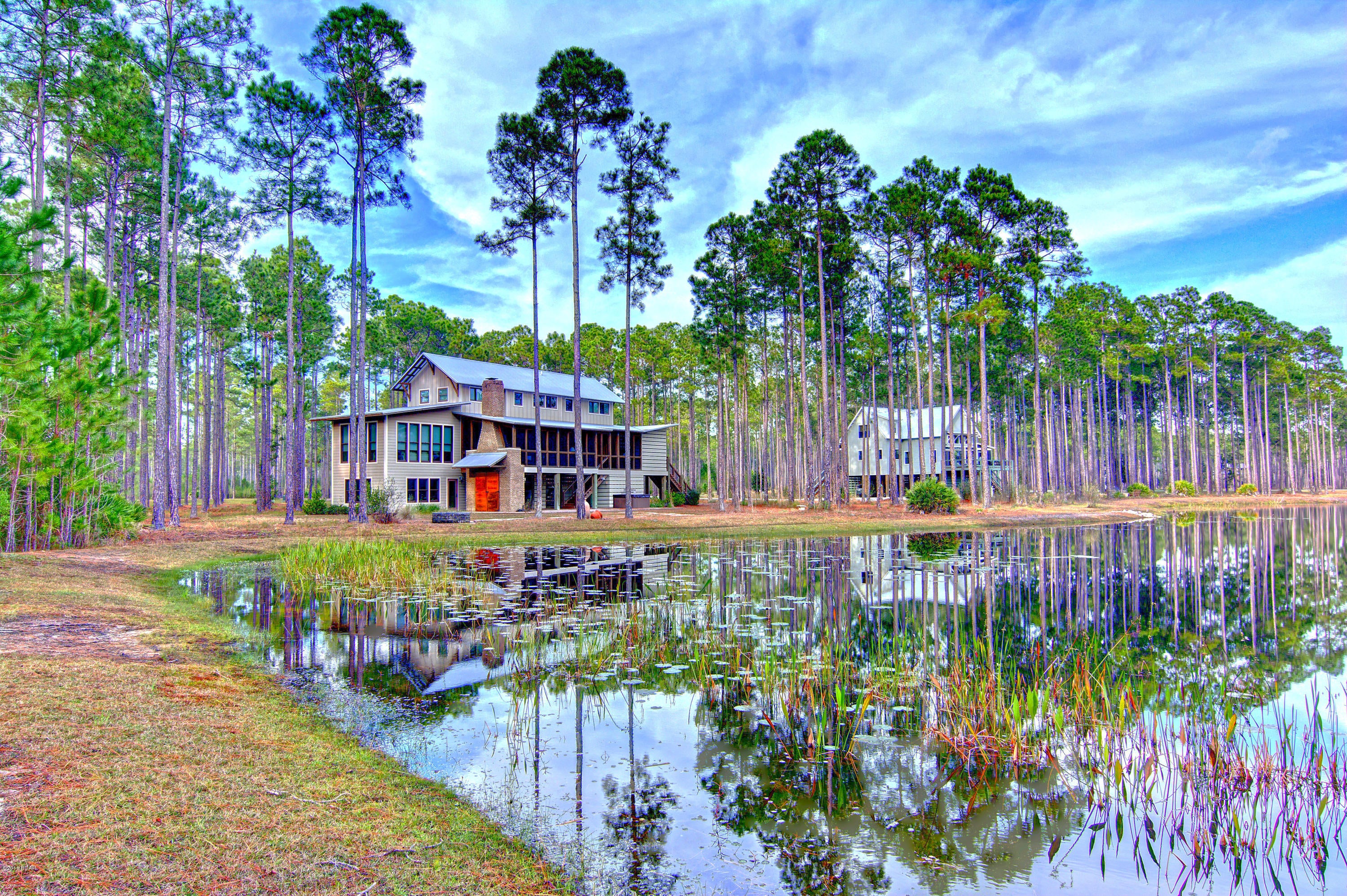 Now selling ''A BETTER IDEA.''  Nestled on a 1,500 acre woodland preserve between the serene waters of Crooked Creek and West Bay, Rivercamps offers a welcome sense of privacy.  These owners took the plans for the award-winning, 2004 Southern Living Idea House and built bigger and better!  Featuring over 1,500 sq. ft. of screened porches and decks, this design is an amazing blend of indoor and outdoor living.   Situated overlooking a beautiful pond, this lovely home offers a little bit of everything for the outdoor enthusiast.  There is a mudroom, two fireplaces and outdoor kitchen along with plenty of rooms, nooks and crannies when bodies are in need of rest and plenty of storage for toys inside and out.  RiverCamps is an exclusive waterfront community, just 10 minutes from the beach and and built among 1,500 acres of pine forest. This gated community is surrounded by three spectacular bodies of water...Crooked Creek, West Bay and the Intracoastal Waterway. Community amenities include the 25,000 square foot RiverHouse, comprised of decks, boardwalks, covered pavilions, heated and cooled spaces and a 600 foot pier that extends into West Bay. The RiverHouse also includes a pool, hot tub, fitness center, library, catering kitchen and dining area. Homeowners and guests can reserve kayaks, canoes and bikes. The community amenities also include an upscale boat basin with a private boat ramp for launching boats up to 27 feet, and approximately eight miles of scenic waterfront walking and biking nature trails! Homeowners and guests also have access to an on-site campground located right on the shores of Crooked Creek. The campground includes restroom and shower facilities. Truly a one-of-a-kind home in a one-of-a-kind community!