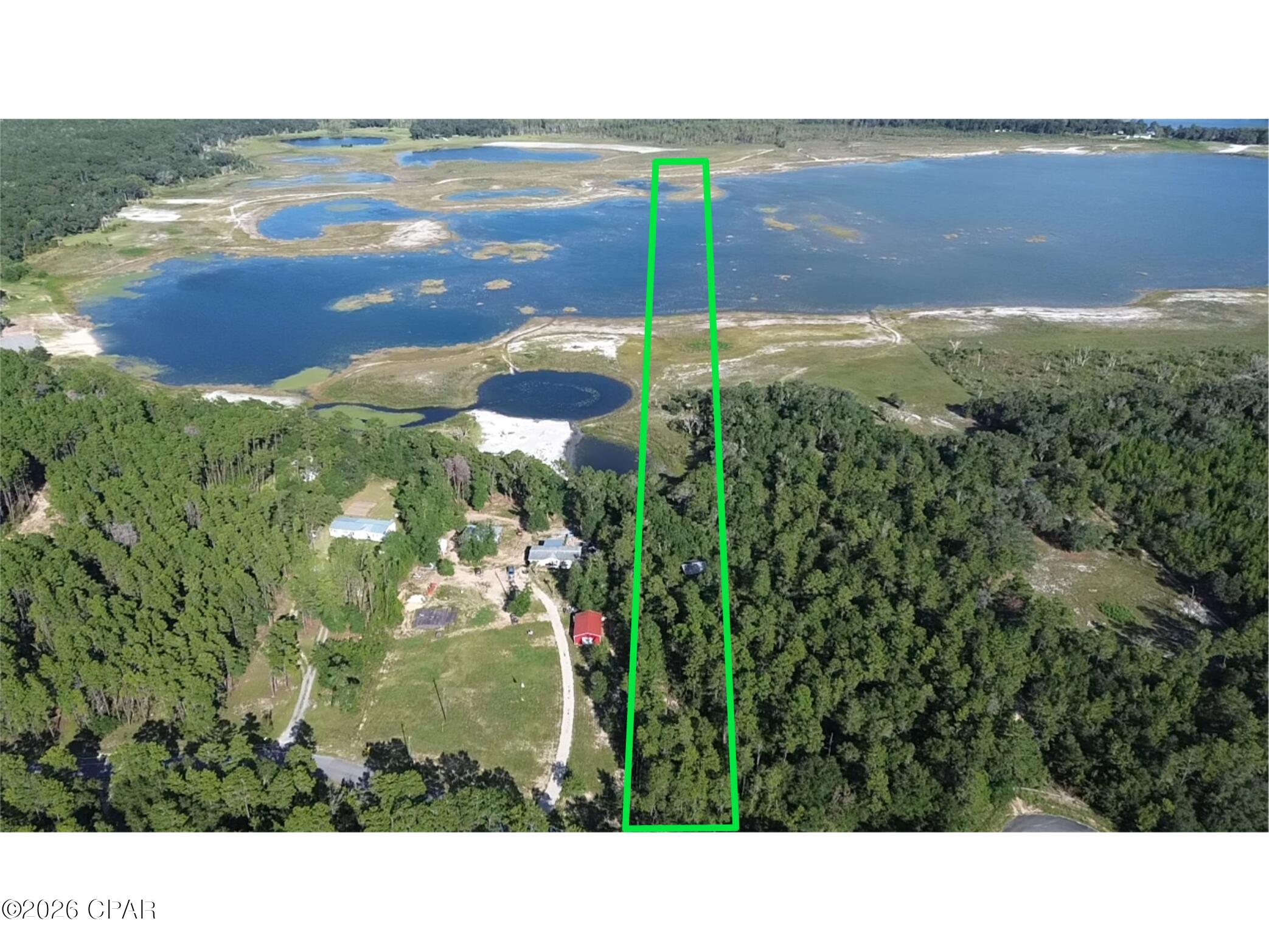 Welcome to your lakeside haven. This remarkable 7.77-acre property offers water frontage on the highly sought-after Hicks Lake, where you can enjoy fishing, boating, and serene views right from your own backyard. The property has a pole barn, is partially cleared providing a perfect balance of open space and natural beauty, and a gated entrance at the beginning of the driveway for added privacy and security.  

Located on a paved road, the property is conveniently less than a mile away from a public boat landing, making lake access effortless. Hicks Lake is unrestricted, allowing you the freedom to bring your vision to life, whether it's building your dream home, setting up a campsite, or investing in a recreational retreat.  

For those seeking both tranquility and convenience, the property is just a 45-minute drive from the white sandy beaches of Panama City Beach, offering the best of both lake and coastal lifestyles. To top it all off, a recent boundary survey has been completed, ensuring a seamless transition for your plans.  

This rare piece of paradise is waiting for you to make it your own. Don't miss the chance to own waterfront property in this prime location.